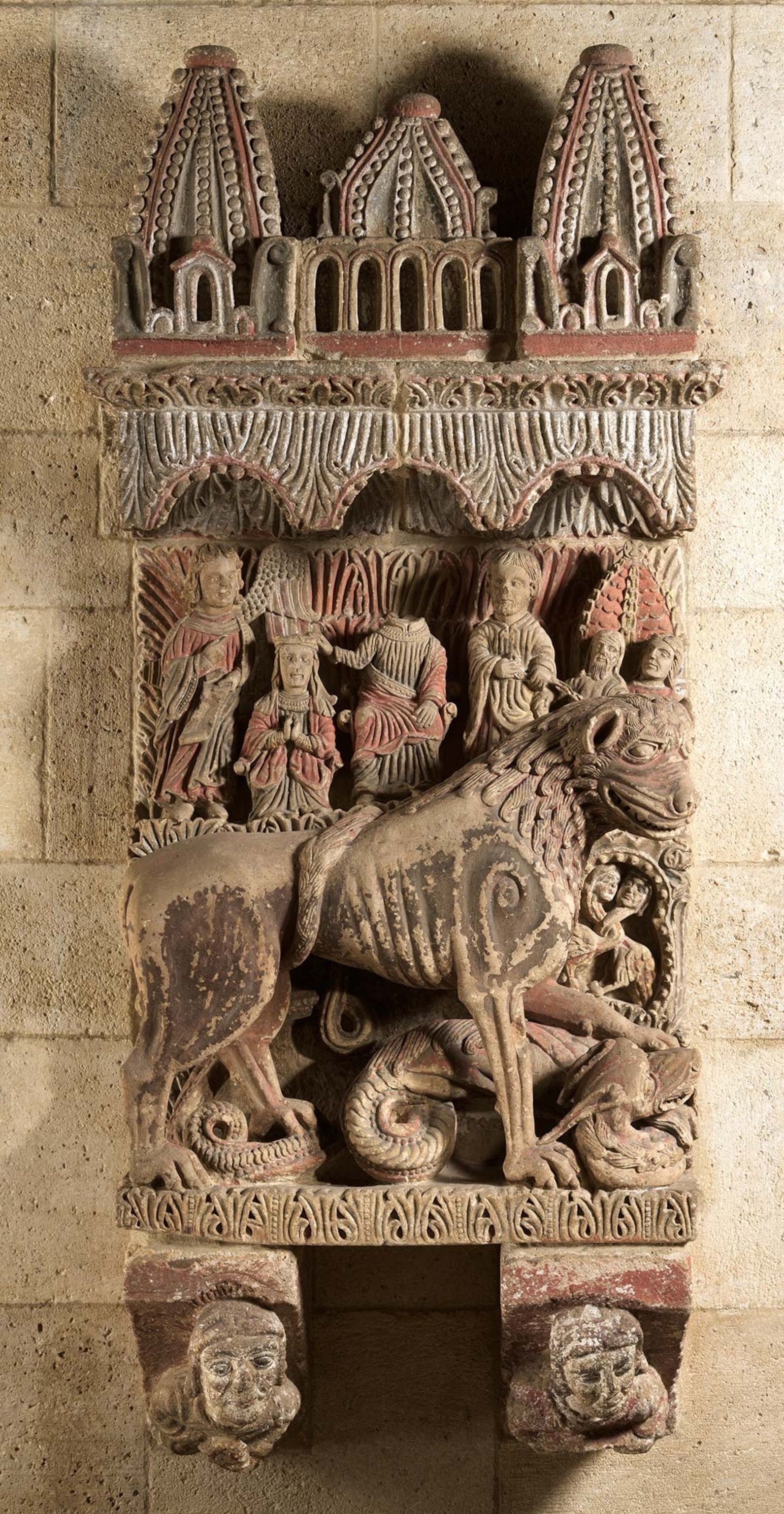 A lion tramples a dragon in a column relief