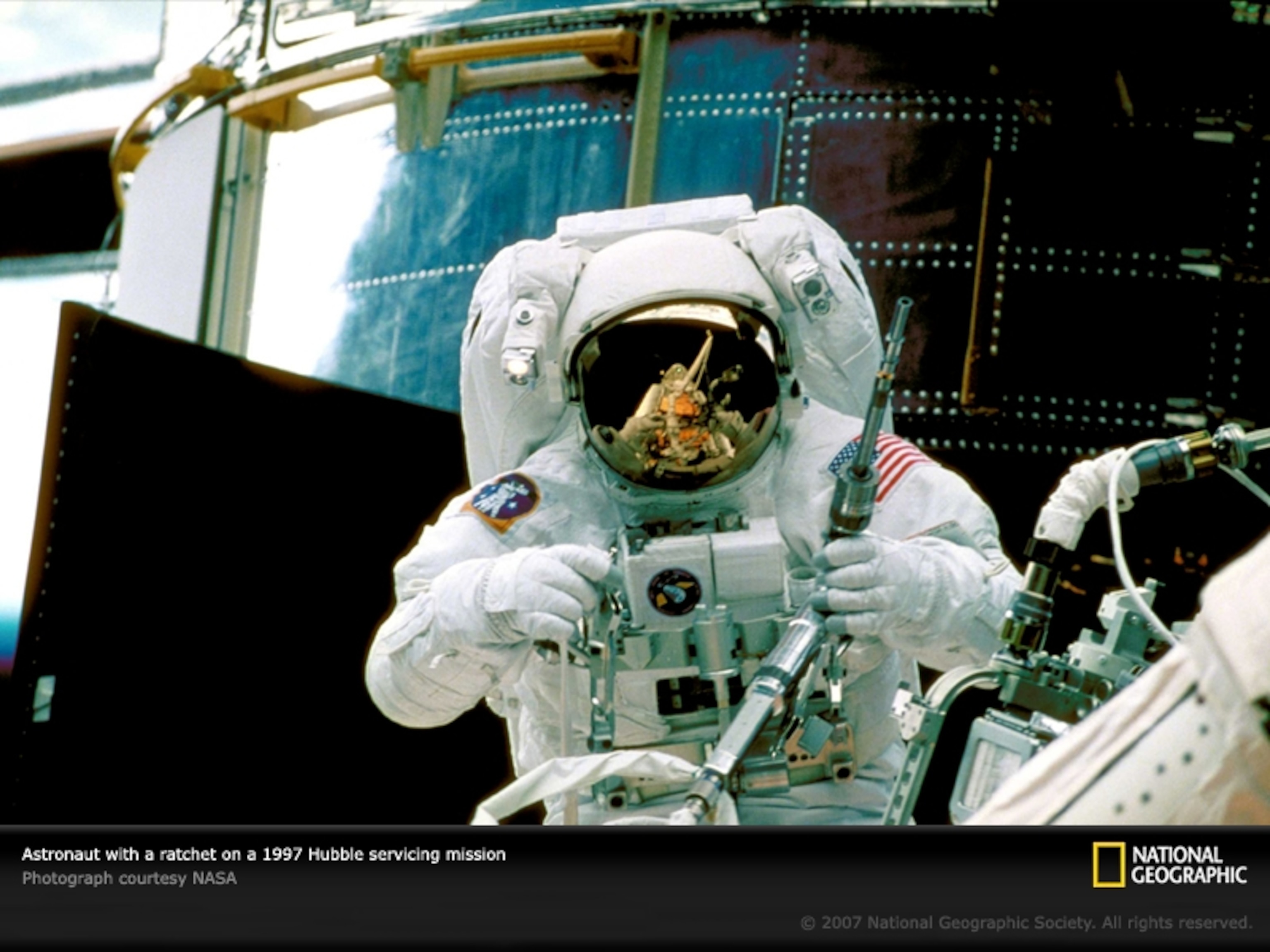 Astronaut with ratchet on Hubble servicing mission