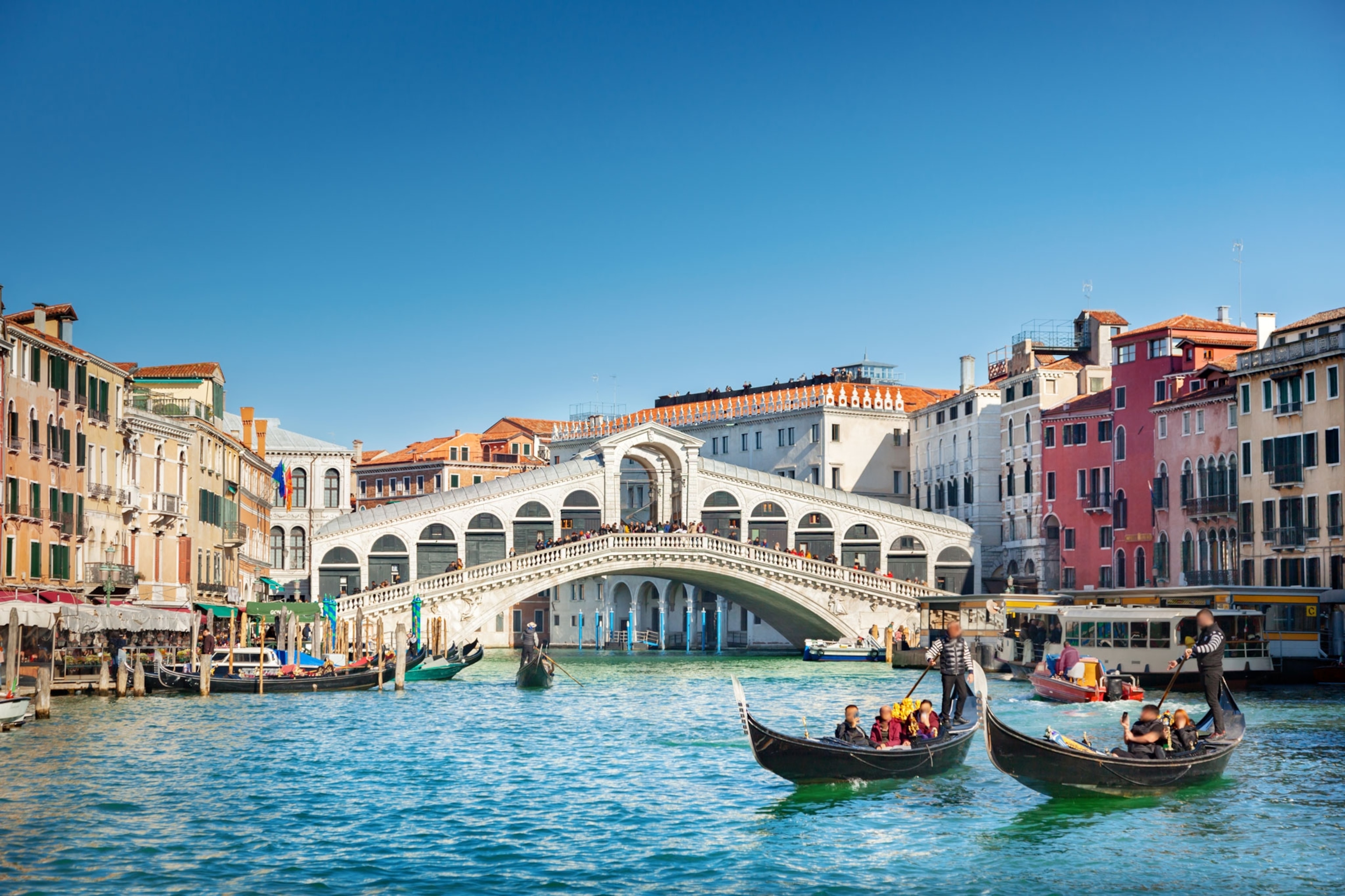 A bridge stands over a canal with boats on the water