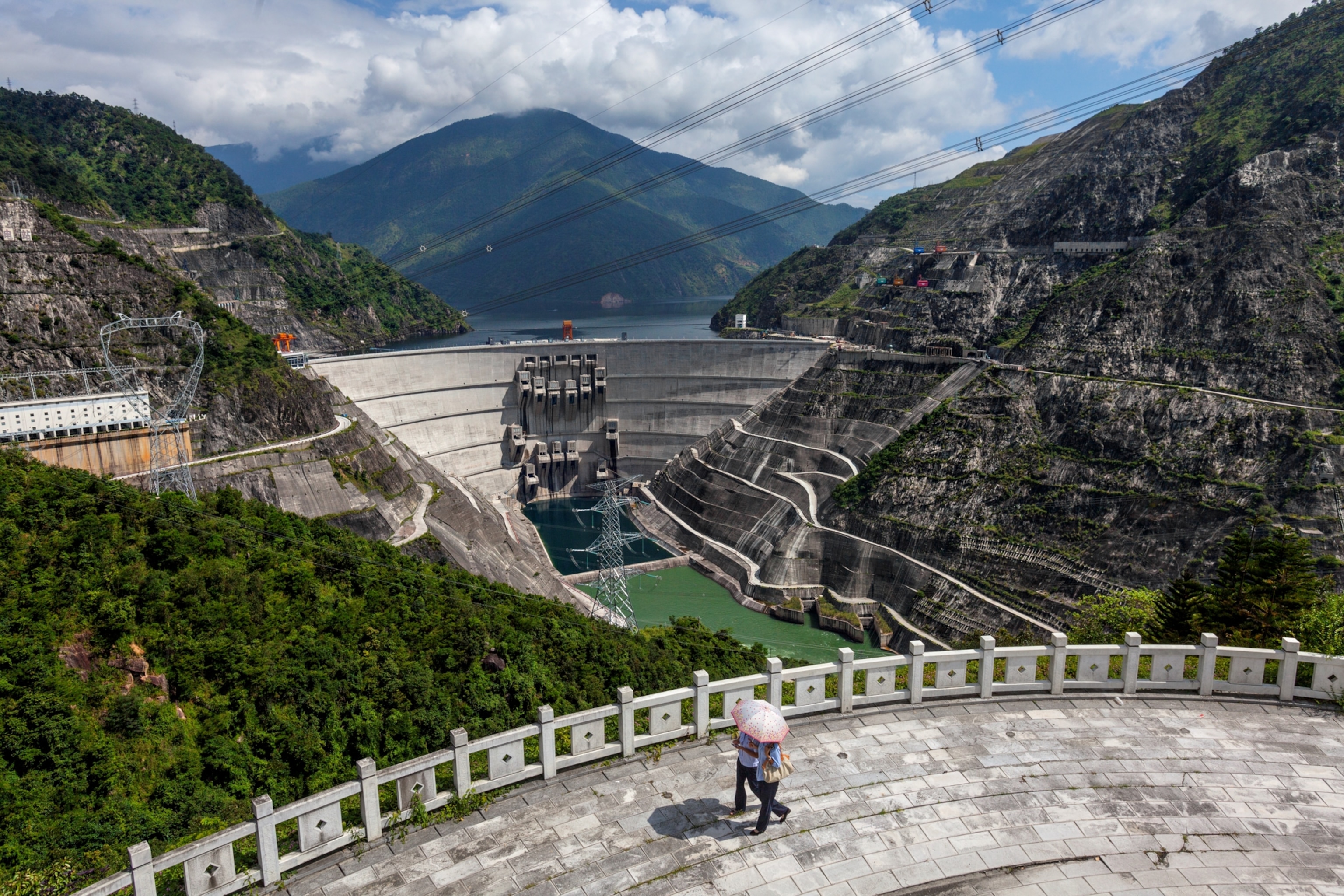 An Aerial view of a dam as people walk along.
