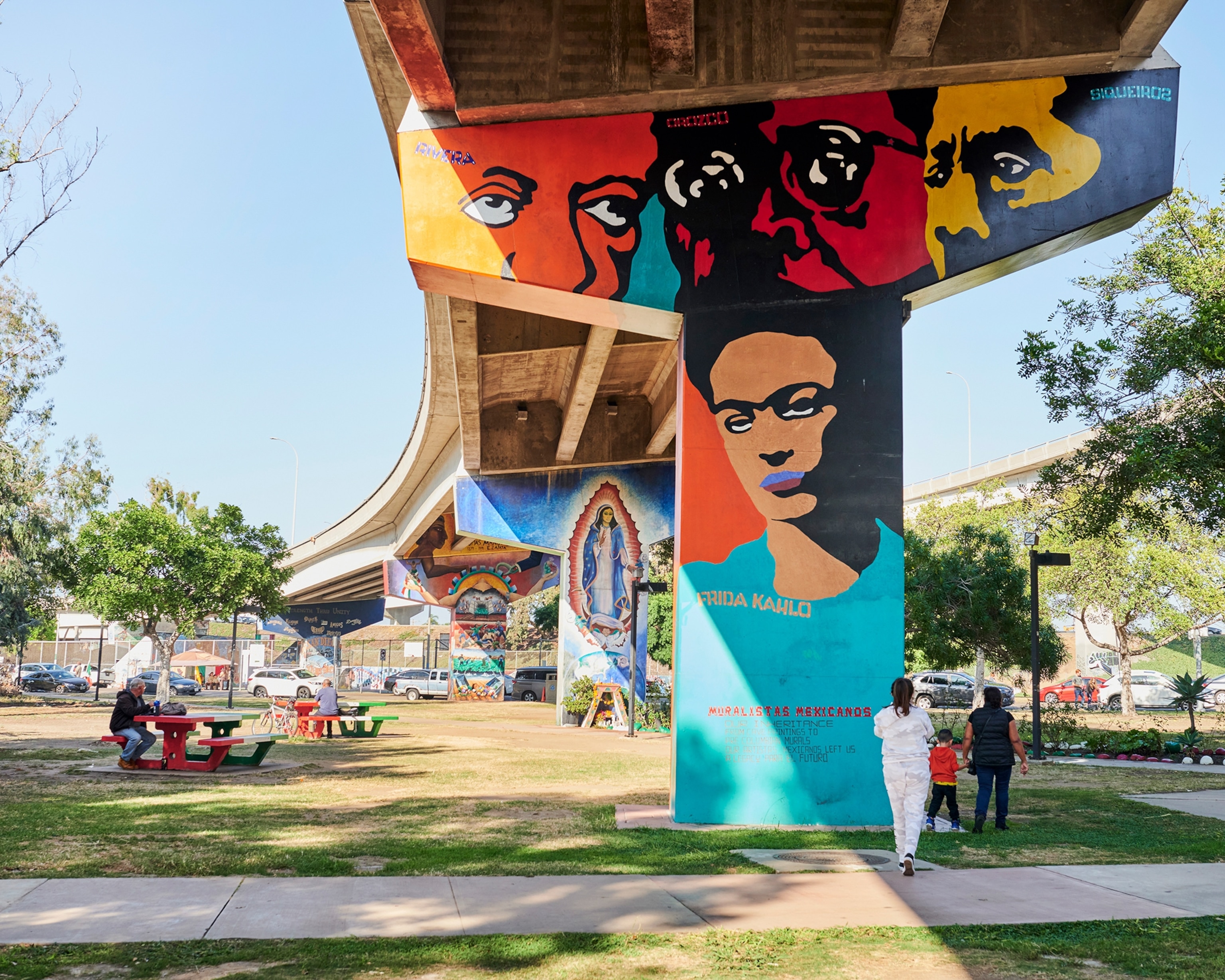 People sit at picnic tables and walk around the colorful Murals at Chicano Park in the Barrio Logan neighborhood n San Diego.