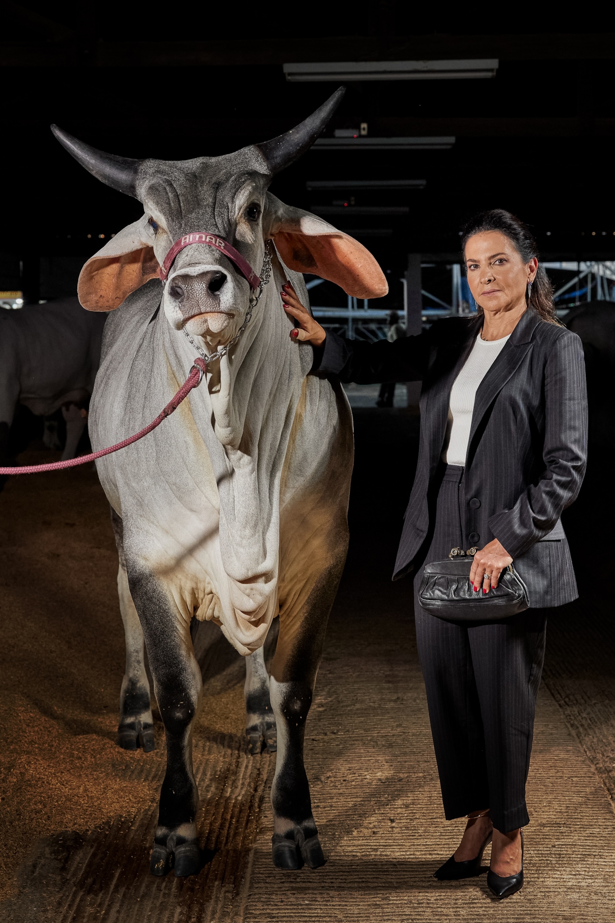 a woman stands next to her cow