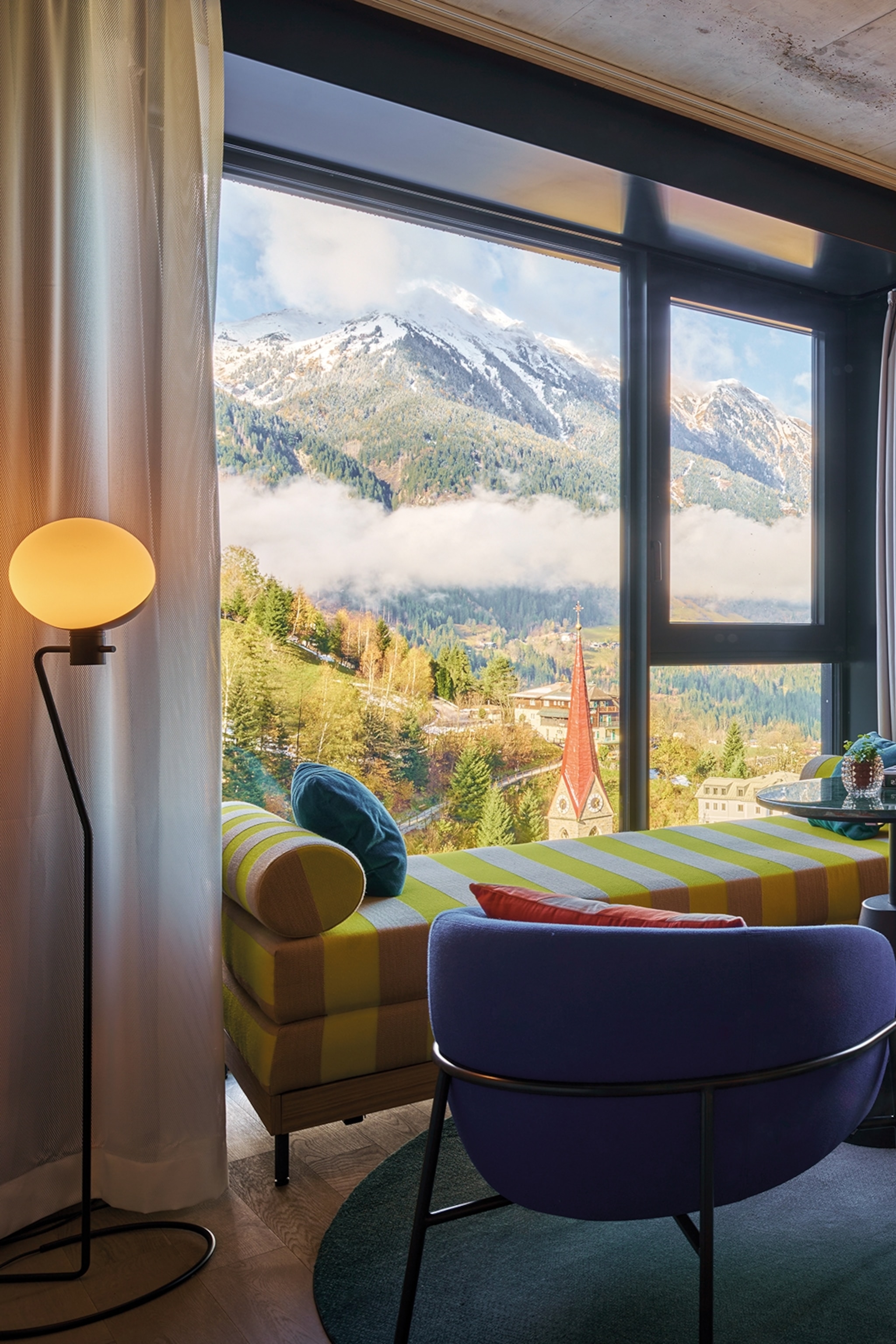 Window overlooking mountains covered in snow with a sofa looking out