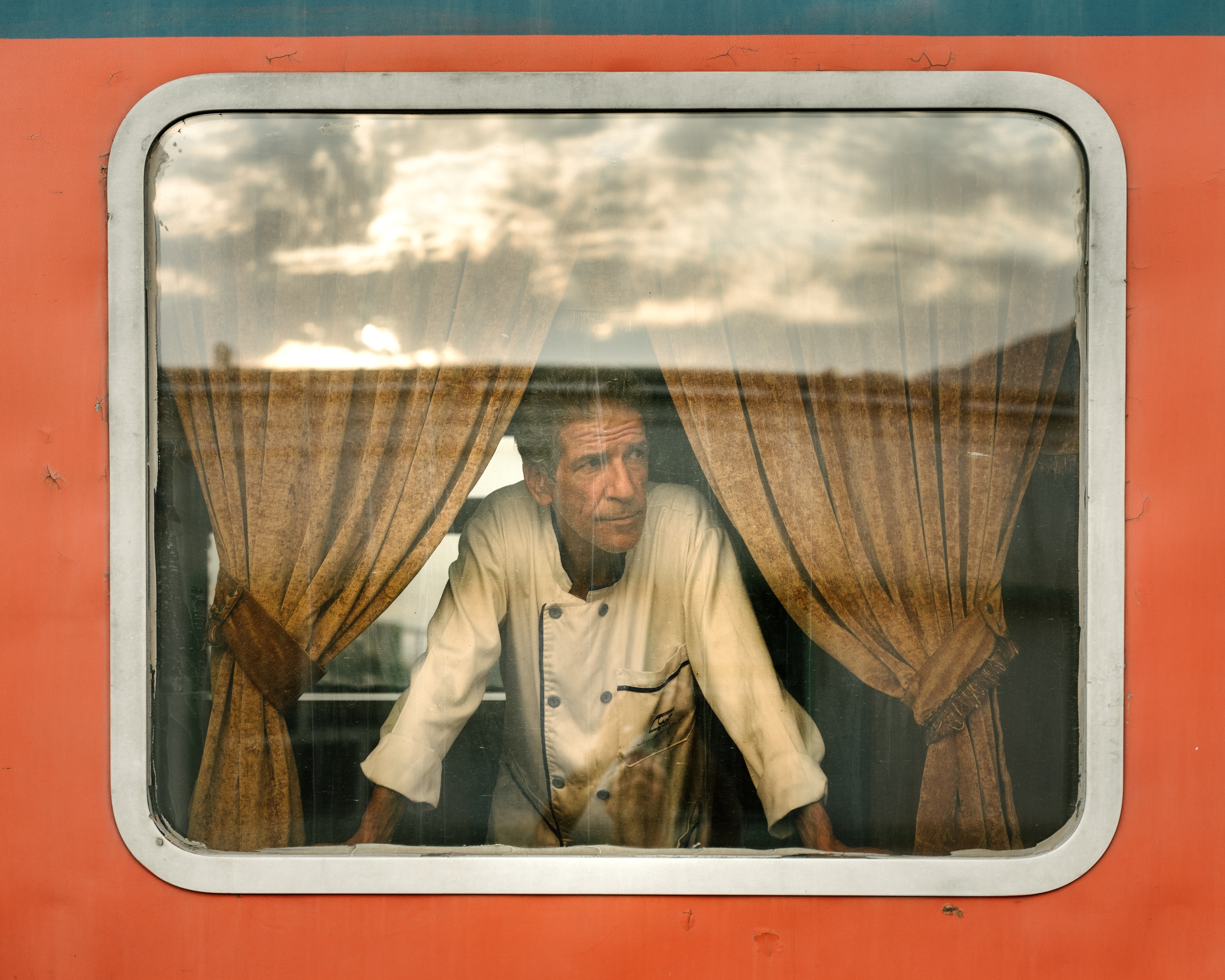 A person leans looking out the window at the train station in Dorud city, Lorestan province