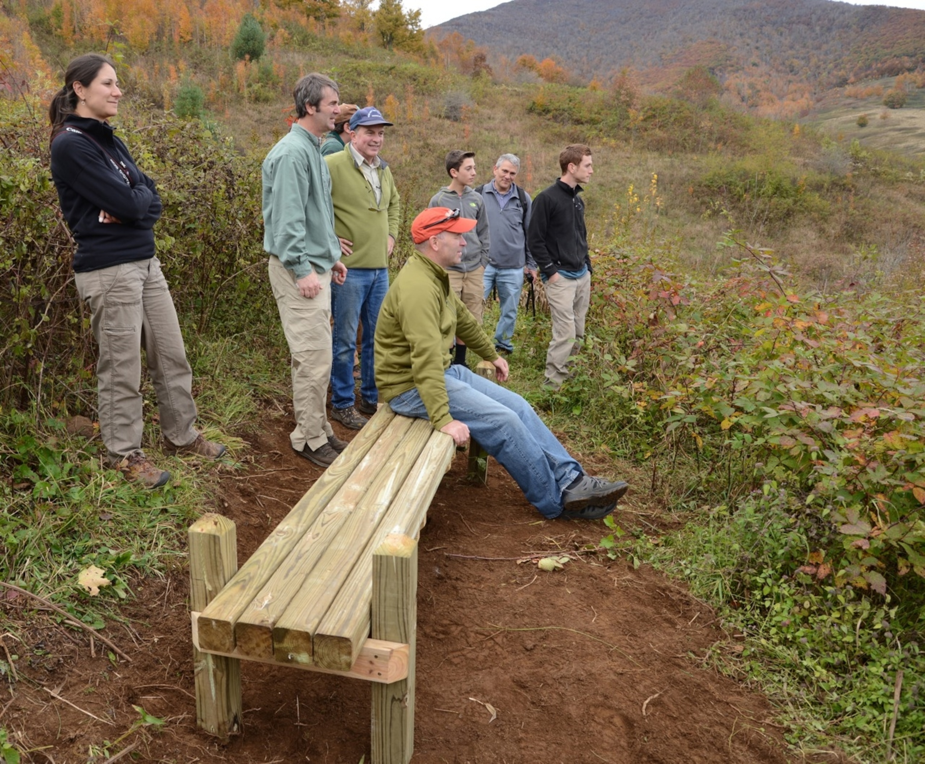 After a day's work, a group of volunteers sits on a birdwatching bench they installed in the newly-acquired habitat in North Carolina's Roan Highlands (Photo by Andrew Evans, National Geographic Traveler)