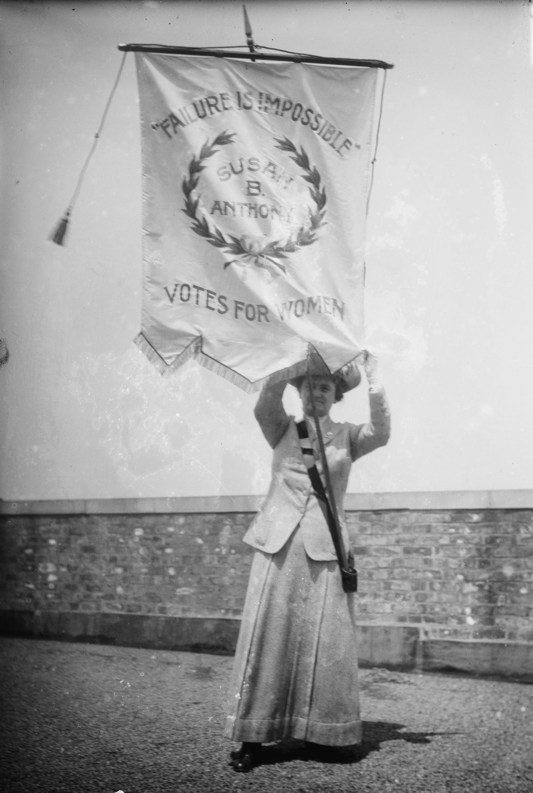 a suffragette holding a banner