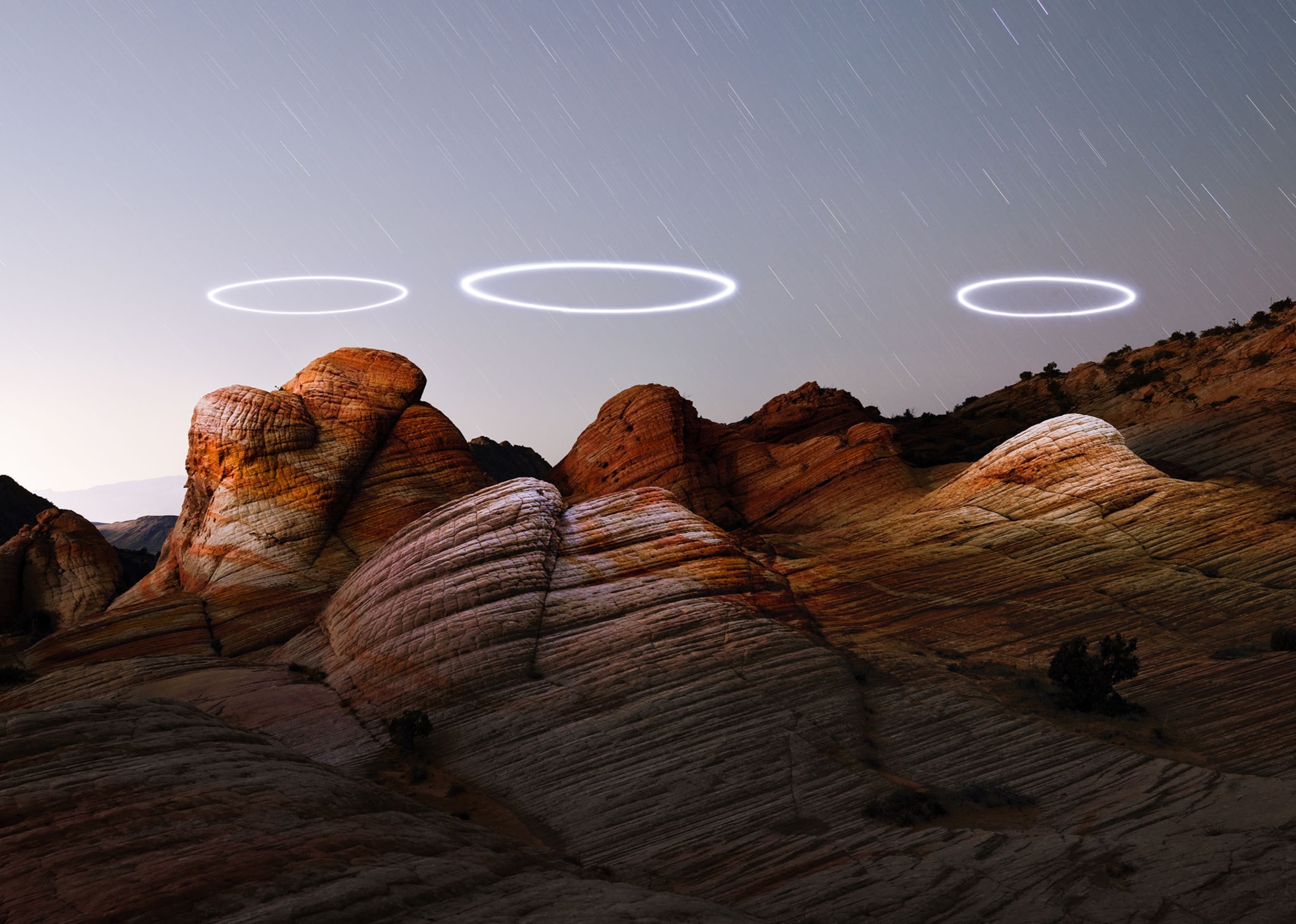 three nimbuses over reddish rocks.