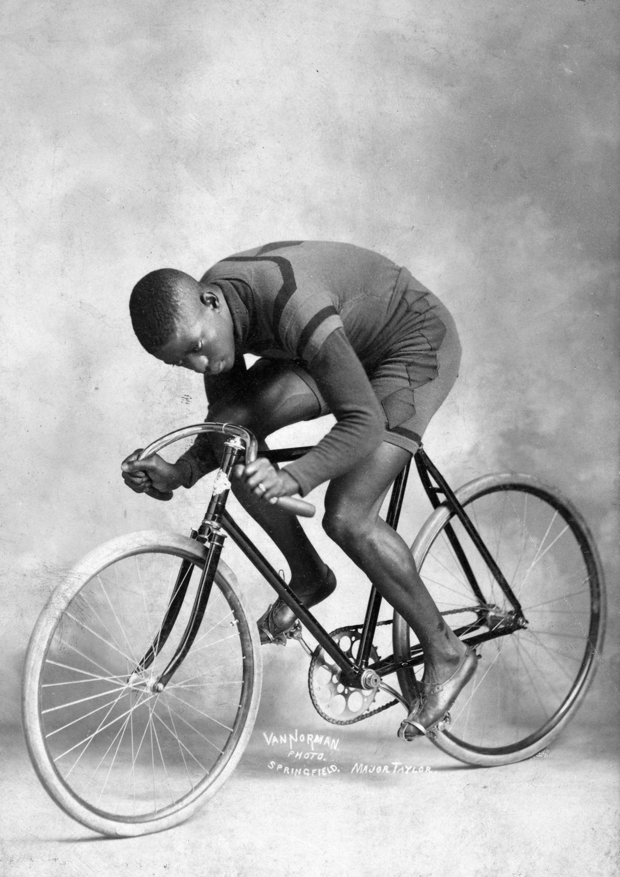 a man posing in a racing stance on a bicycle