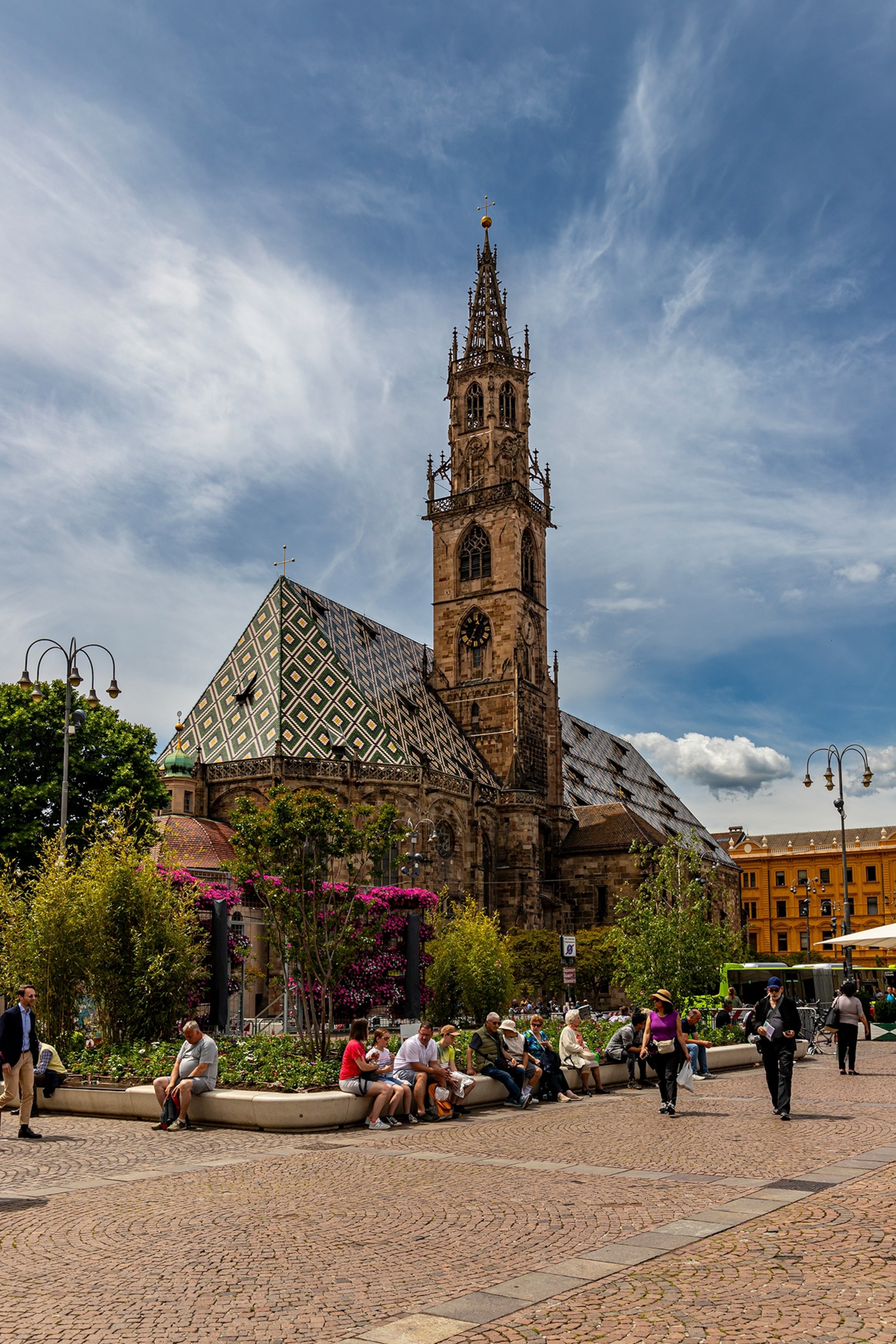 People walk along the streets under a blue sky.