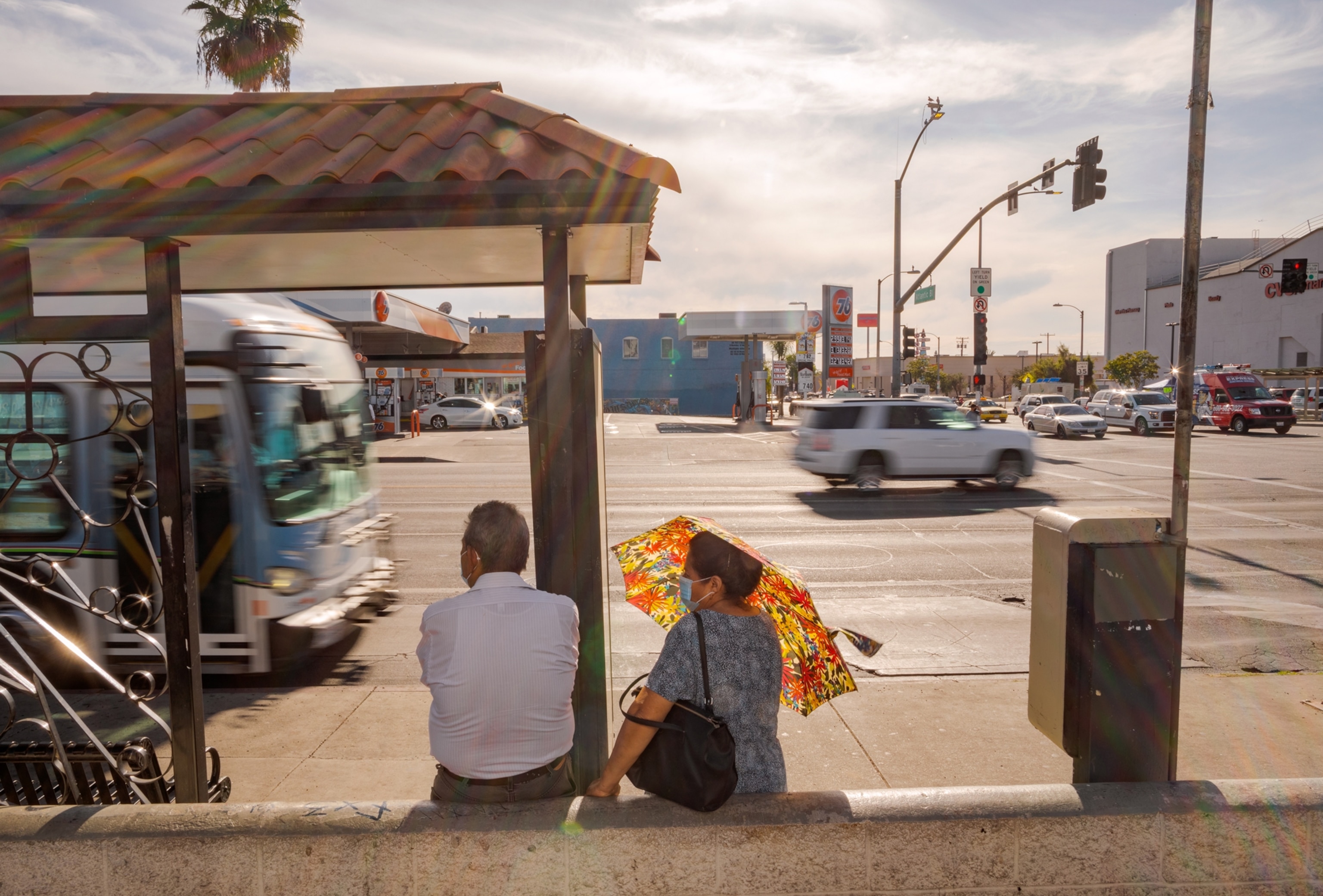 Picture of man and woman waiting for a bus at the bus stop