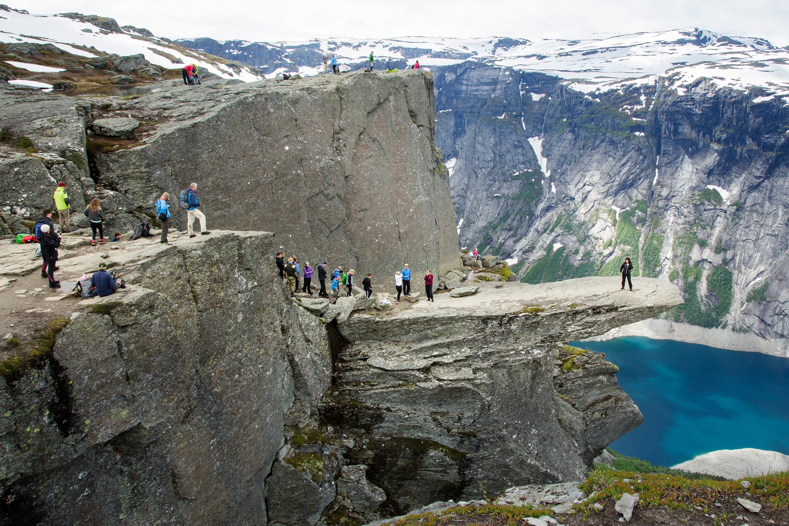 tourists taking photos on Trolltunga in Tyssedal, Norway