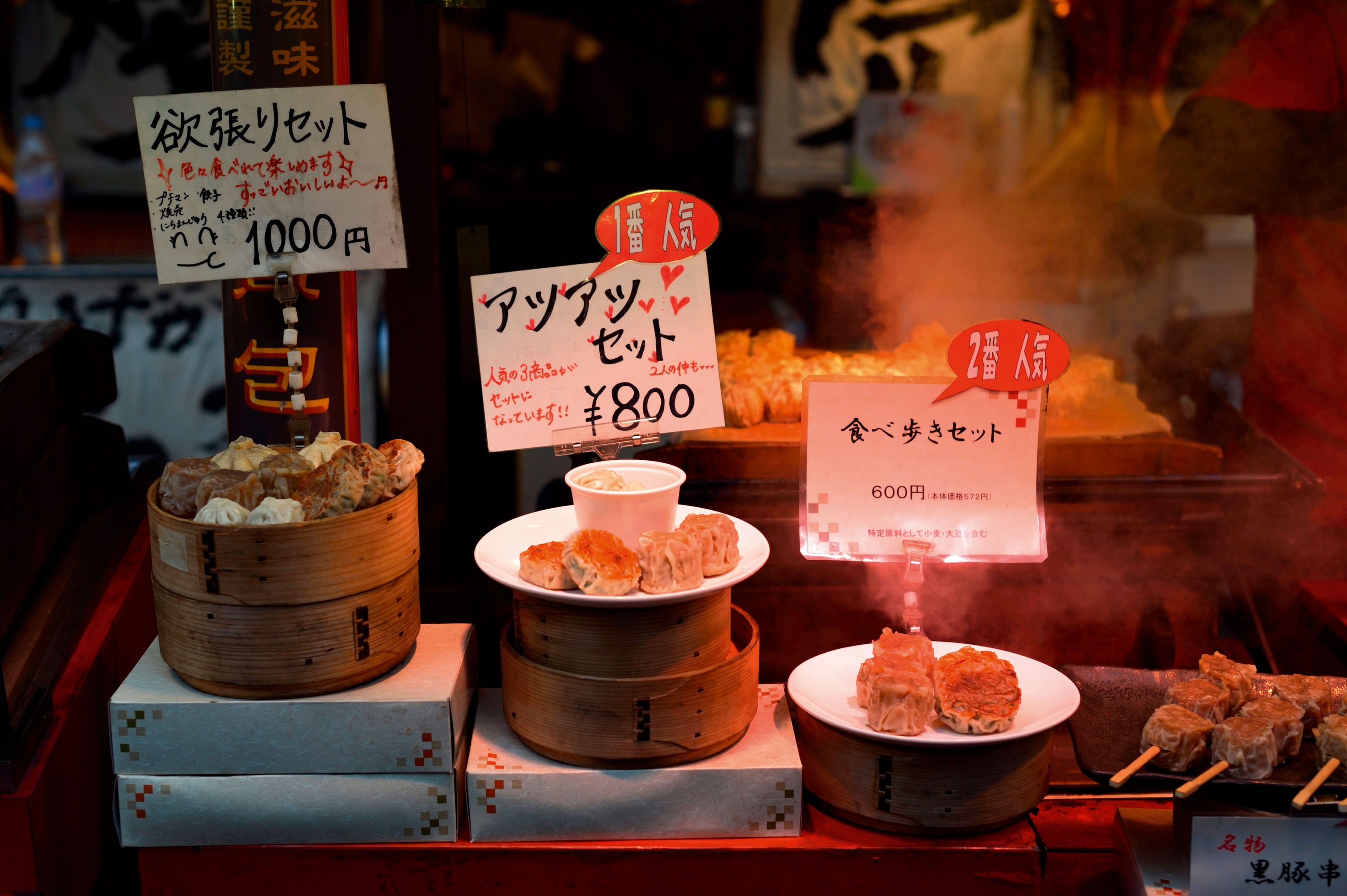 brightly lit image of chinese dumplings on display with price cards attached