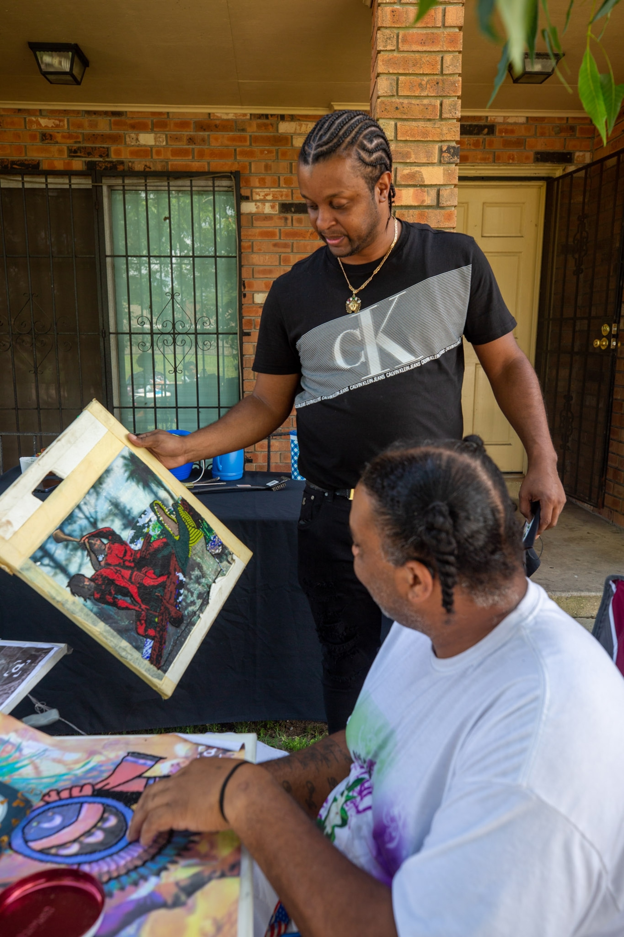 a person holding a sketch out for another person to see