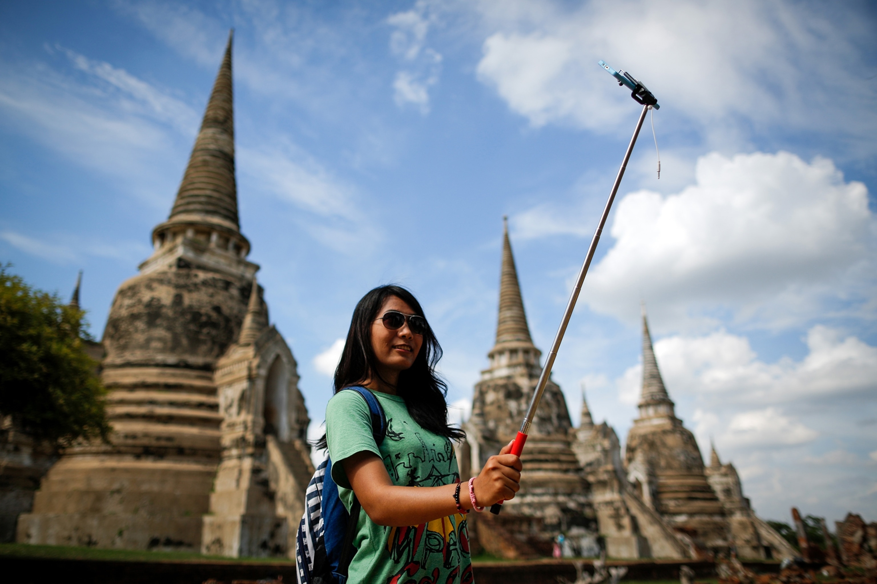 a woman taking her picture with a selfie stick, Thailand