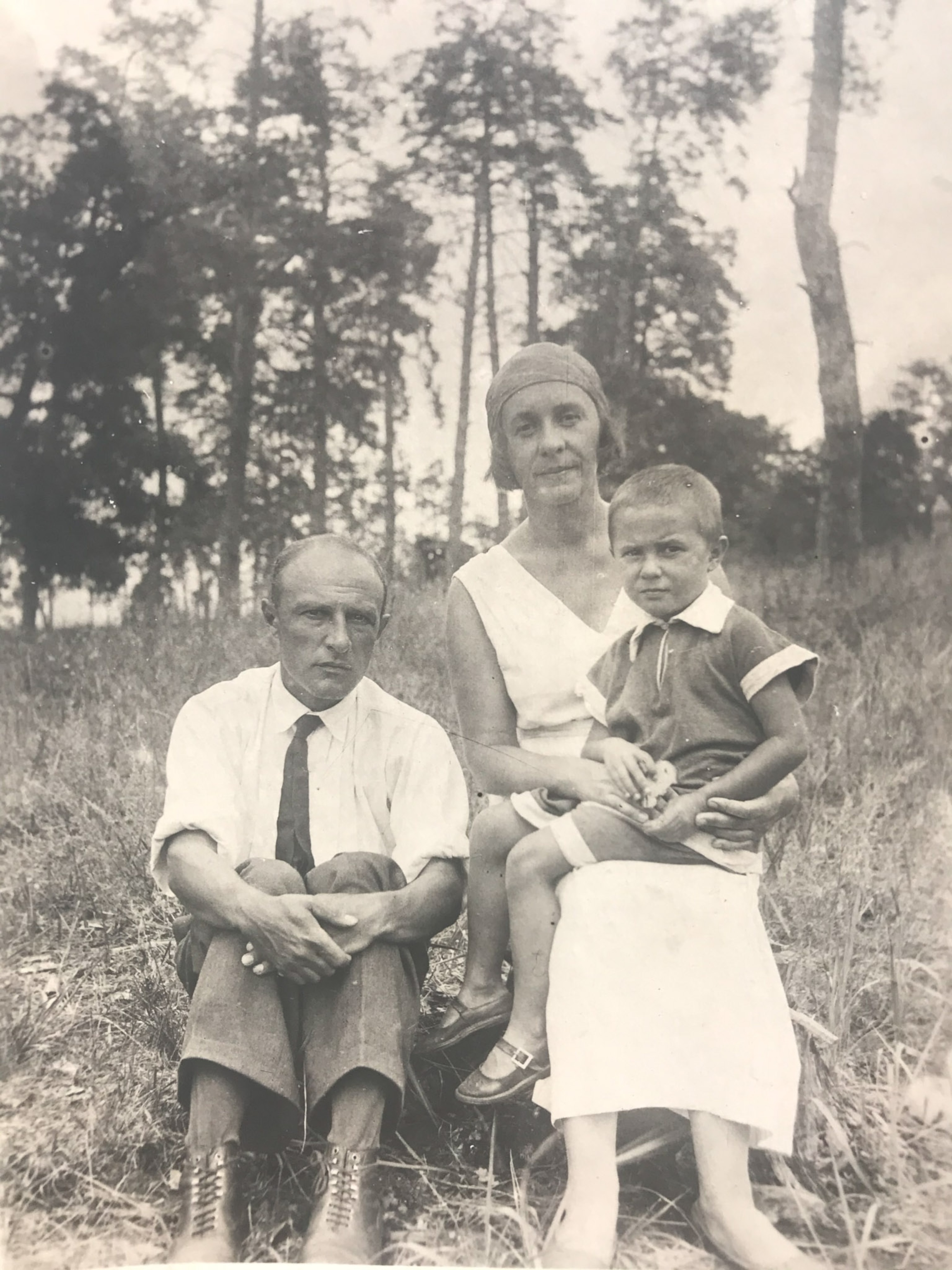 a daughter sitting in her mother's lap with her father beside them