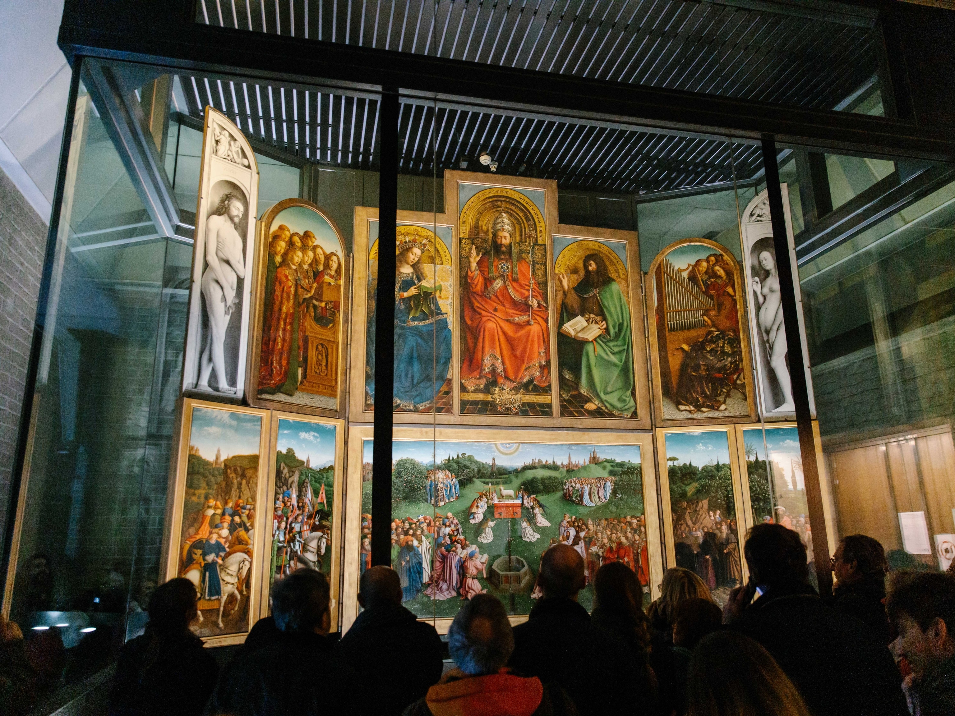 Visitors admire The Adoration of the Mystic Lamb altarpiece inside St Bavo's Cathedral.