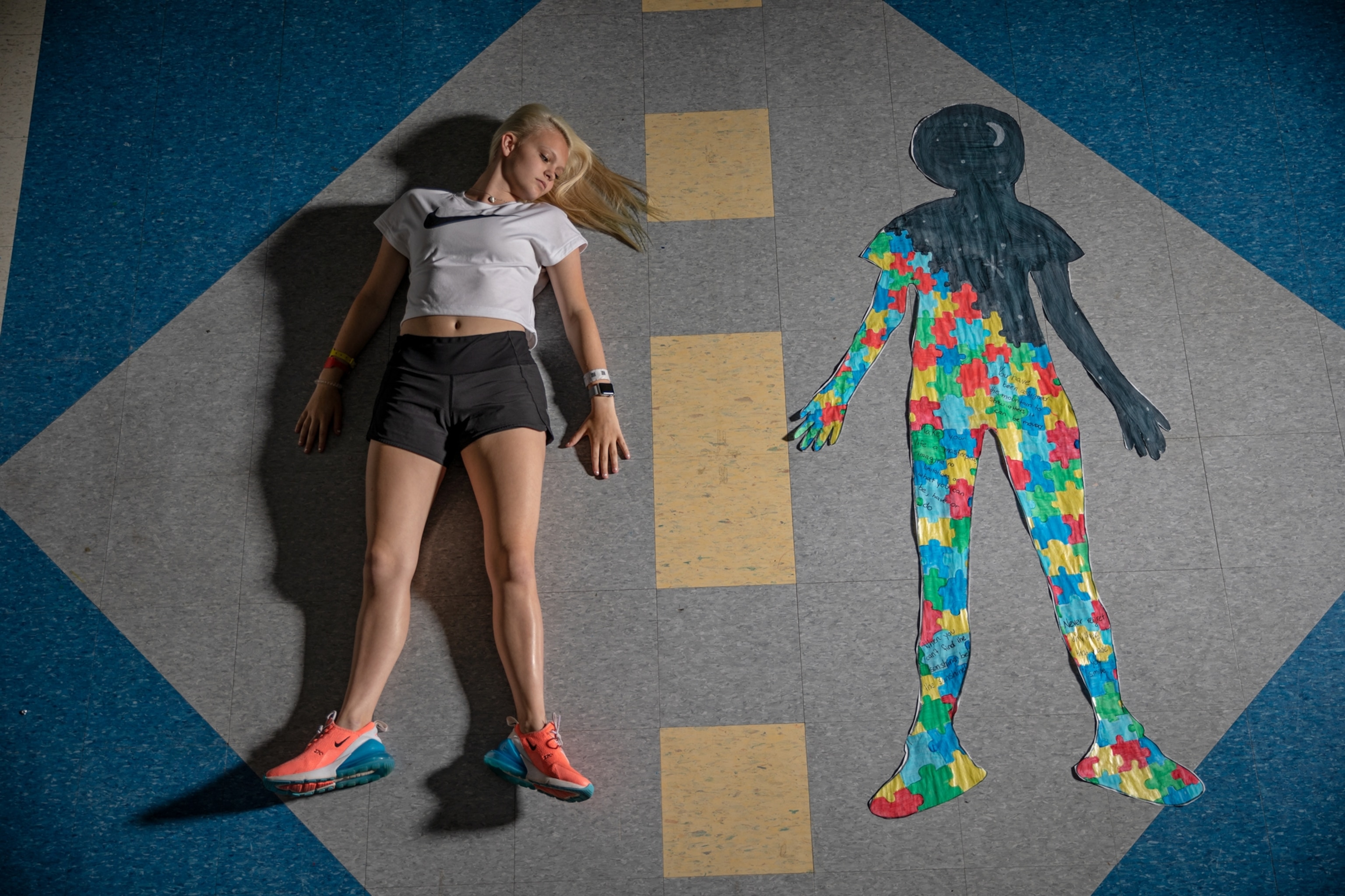 a girl lying on floor next to her silhouette.