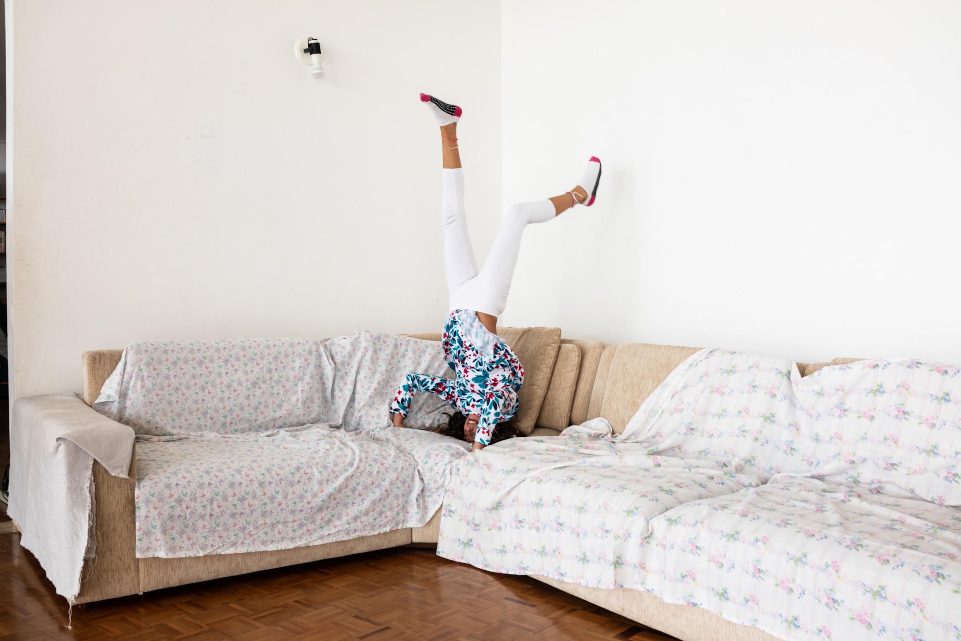 a young girl doing a handstand on a couch