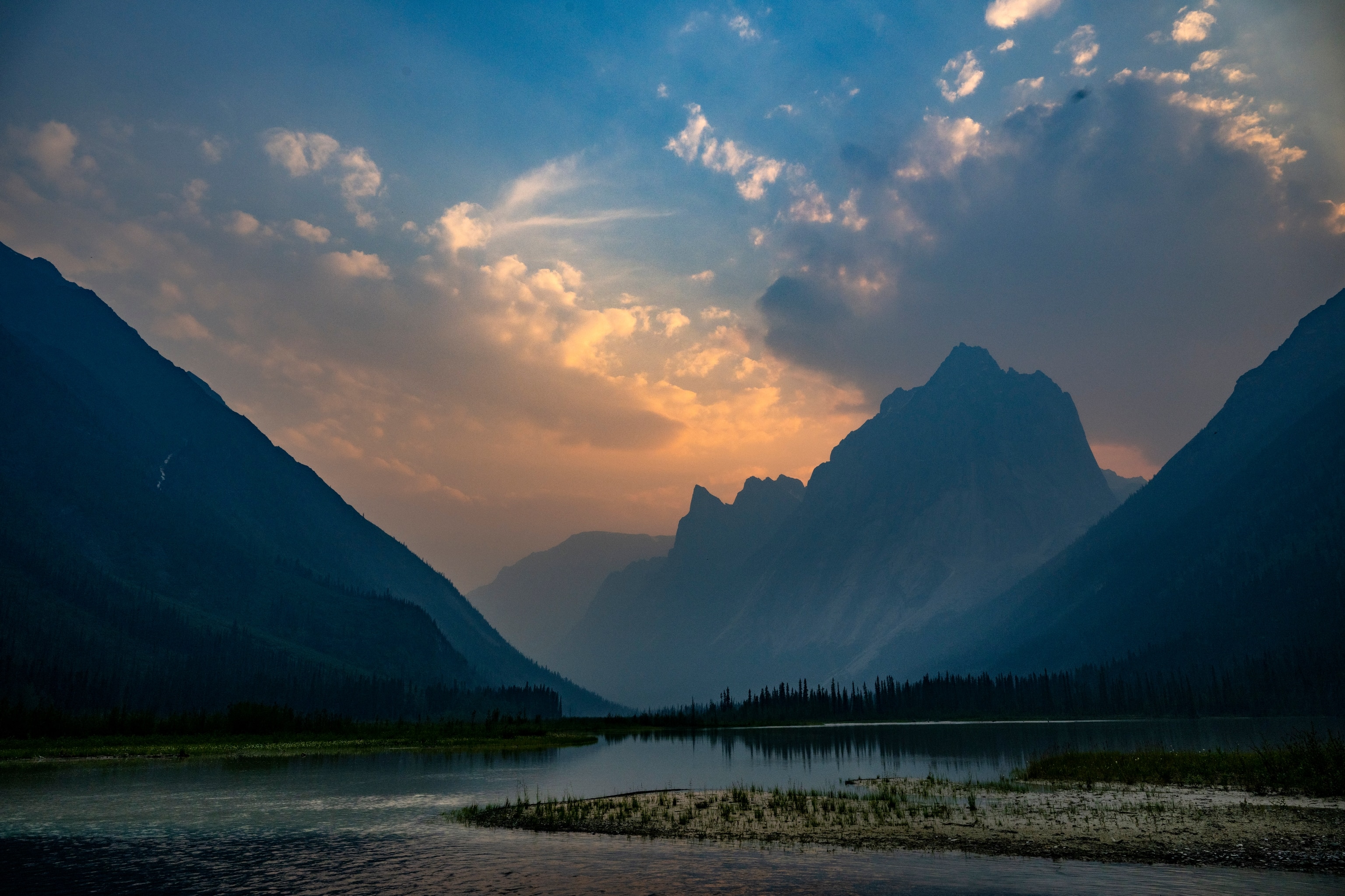As midnight approaches in Glacier Lake in the Northwest Territories of Canada, sunlight illuminates the Cirque of the Unclimbables mountains.