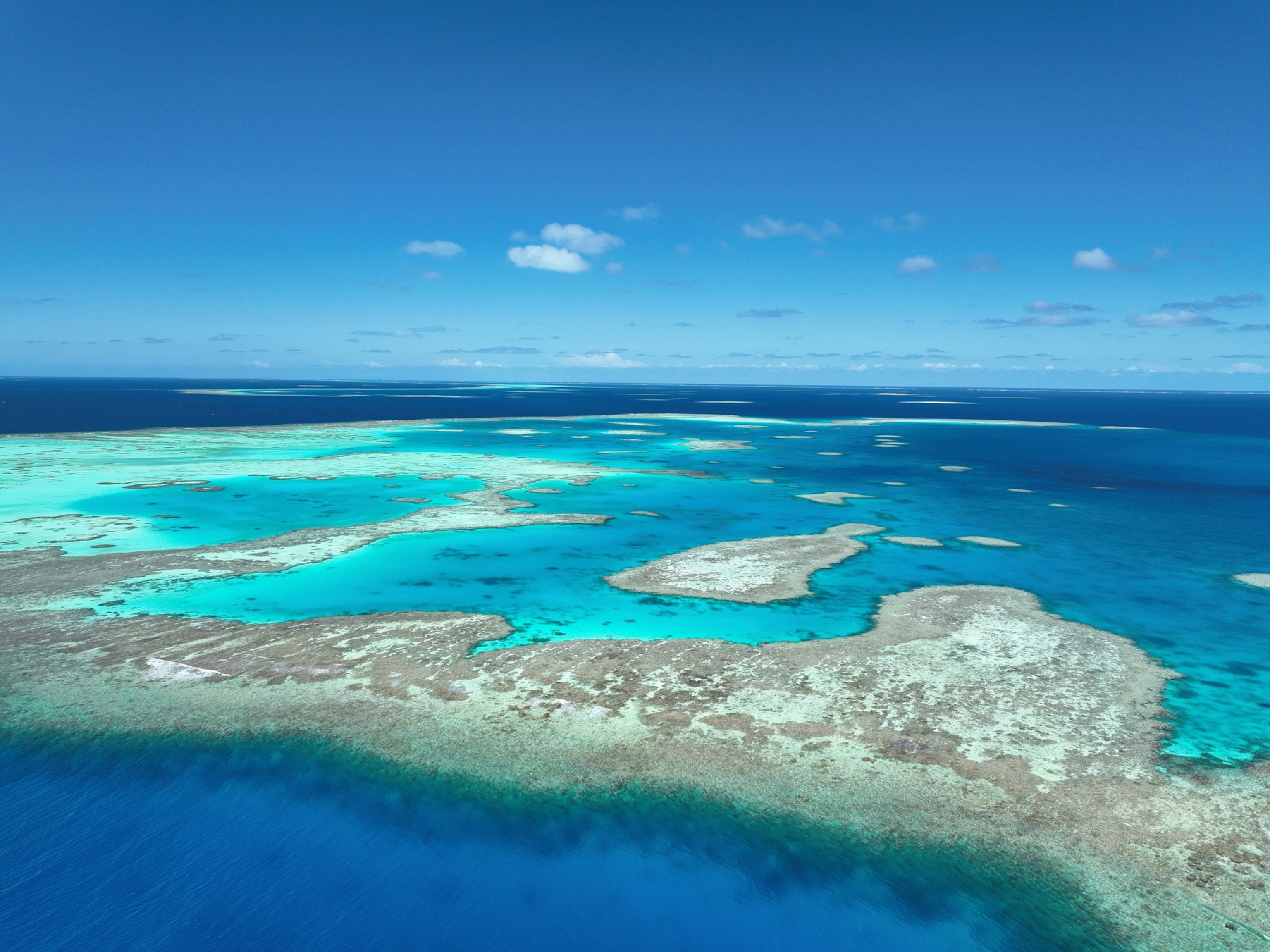 An aerial view of an island around bright blue seas.