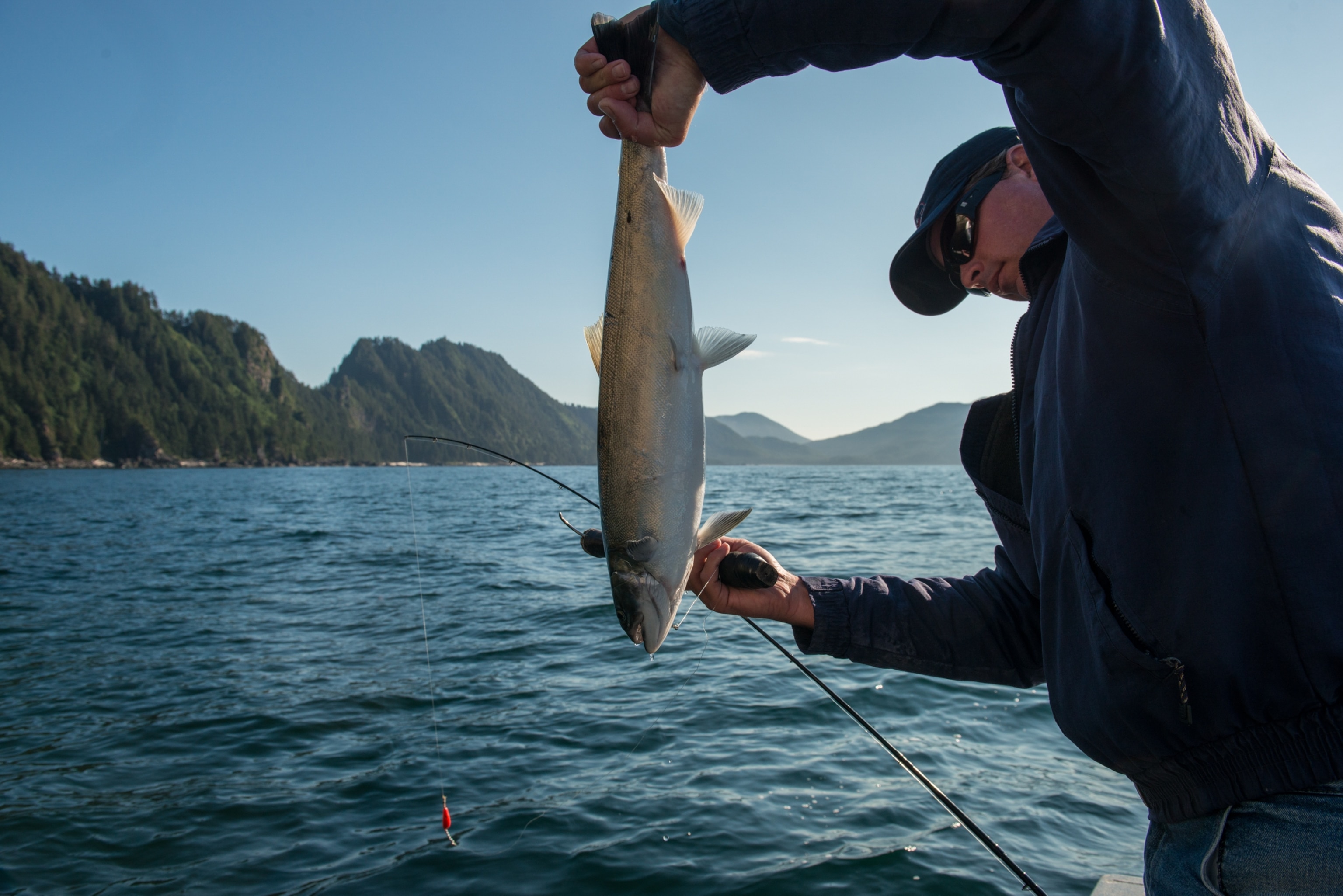 A fishing guide fishes for salmon from a small sport fishing boat