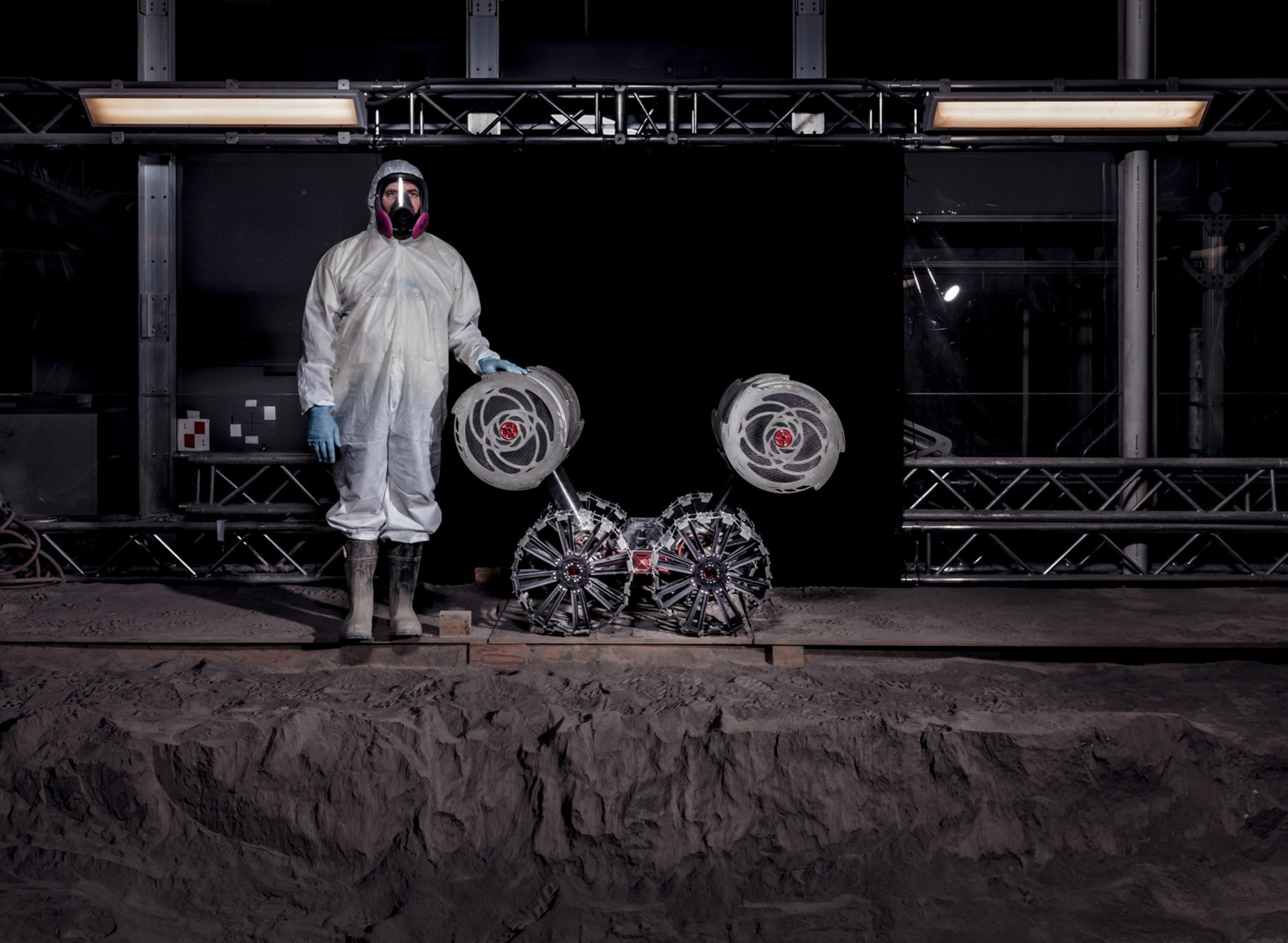 a man in a lab suit caressing a robot vehicle
