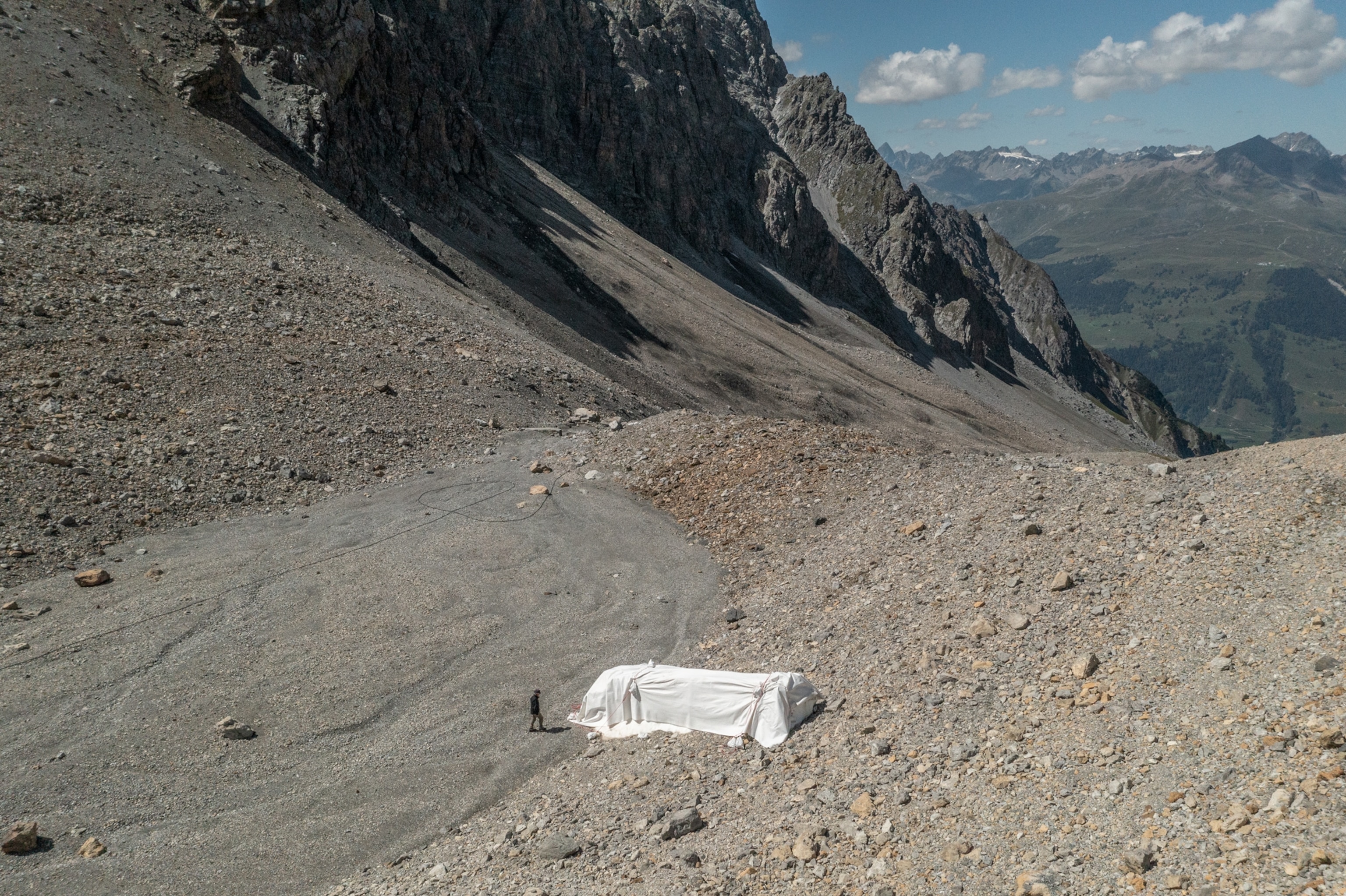 Picture of aerial view of mountain ridge with pile of snow covered with fabric