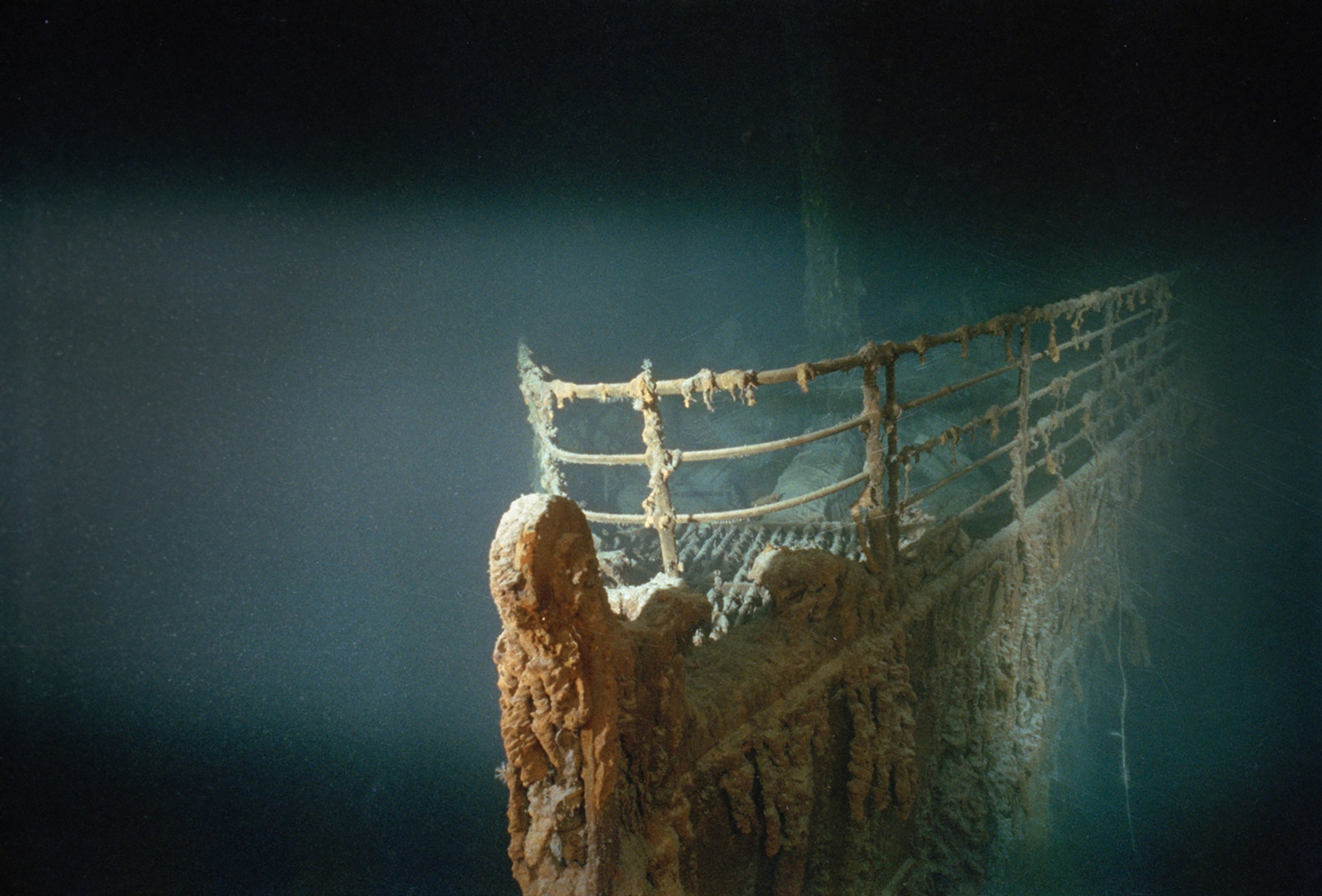 A light shines on the bow of the ship a thick layer of growth and rust.