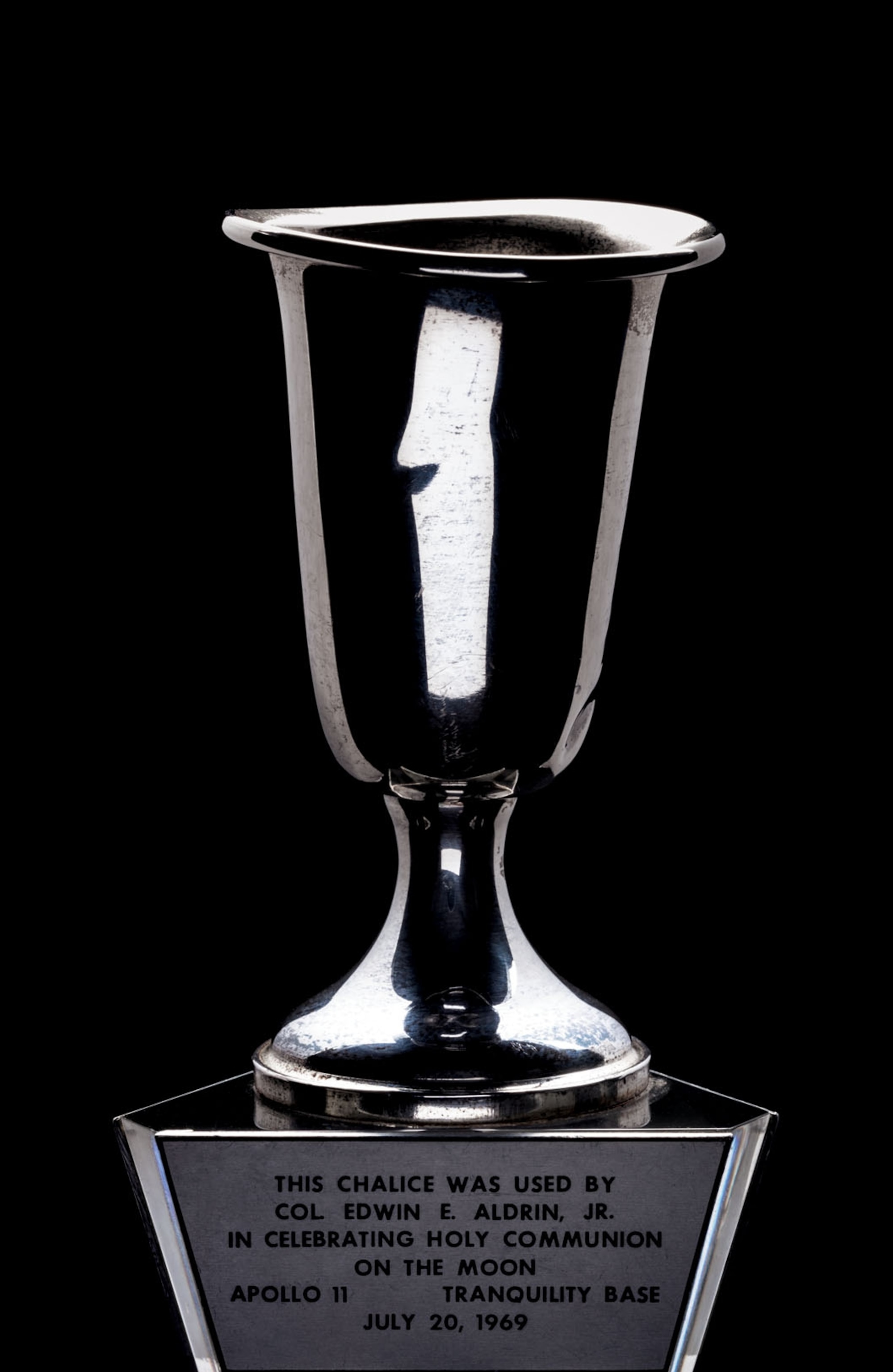 a silver chalice on an engraved pedestal
