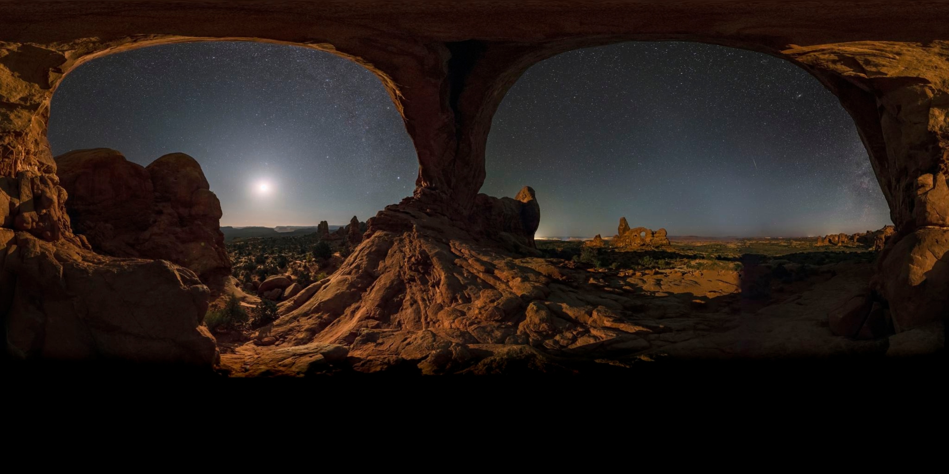Night sky and moonlight seen through a giant natural arch