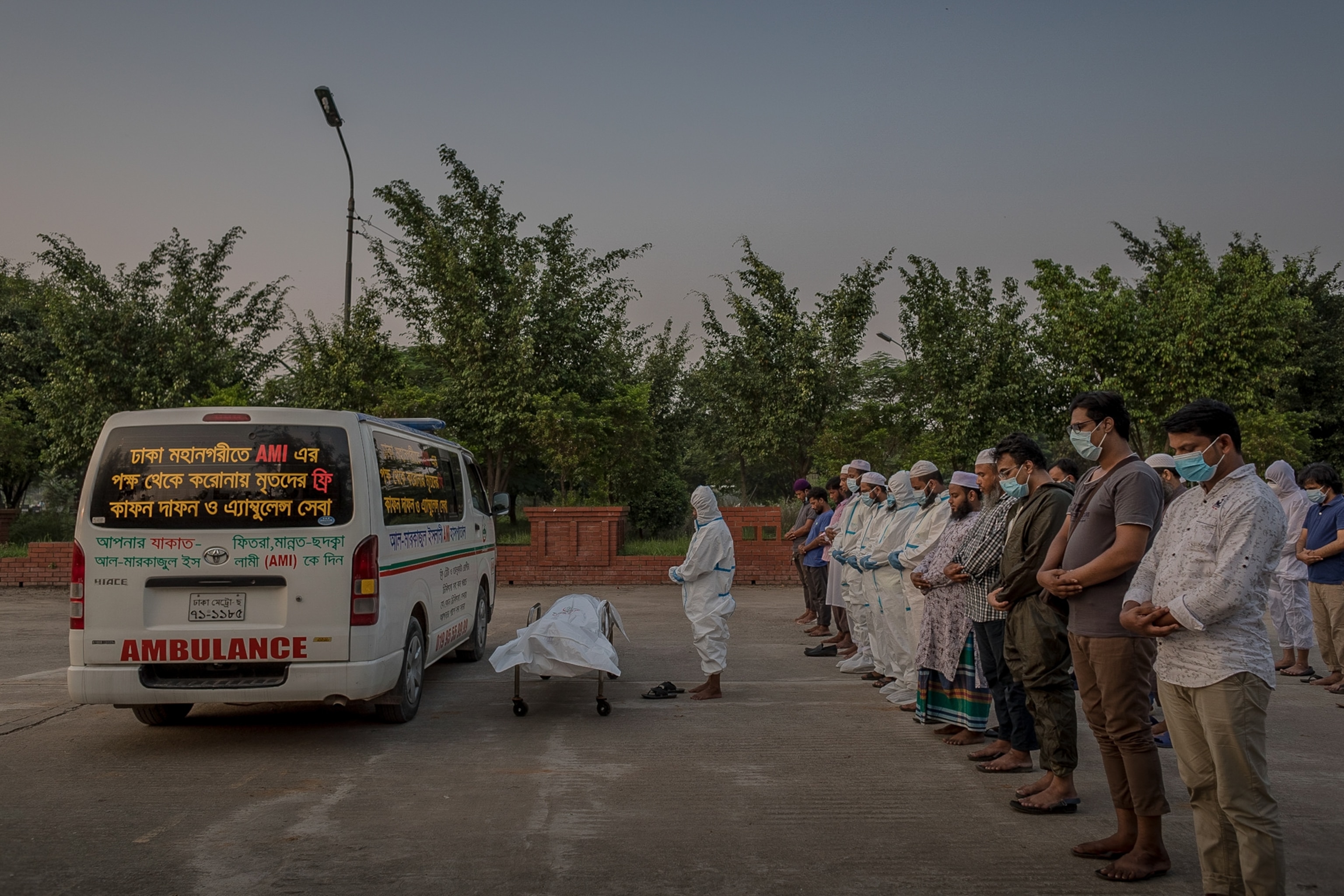 burial wokers conduct a prayer over a Covid-19 victim in Bangladesh