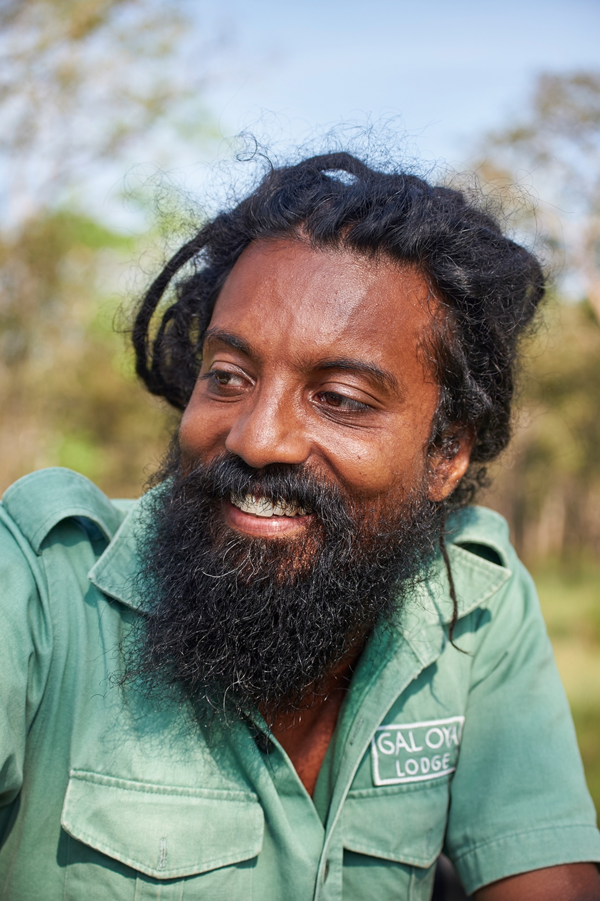 Man wearing a green uniform smiling
