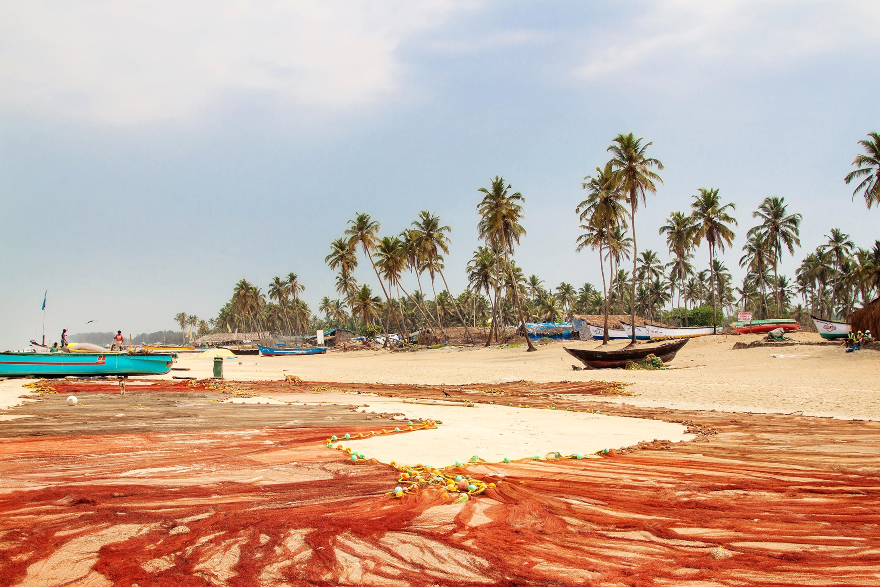 fishing boats and nets on beach in Colva, India
