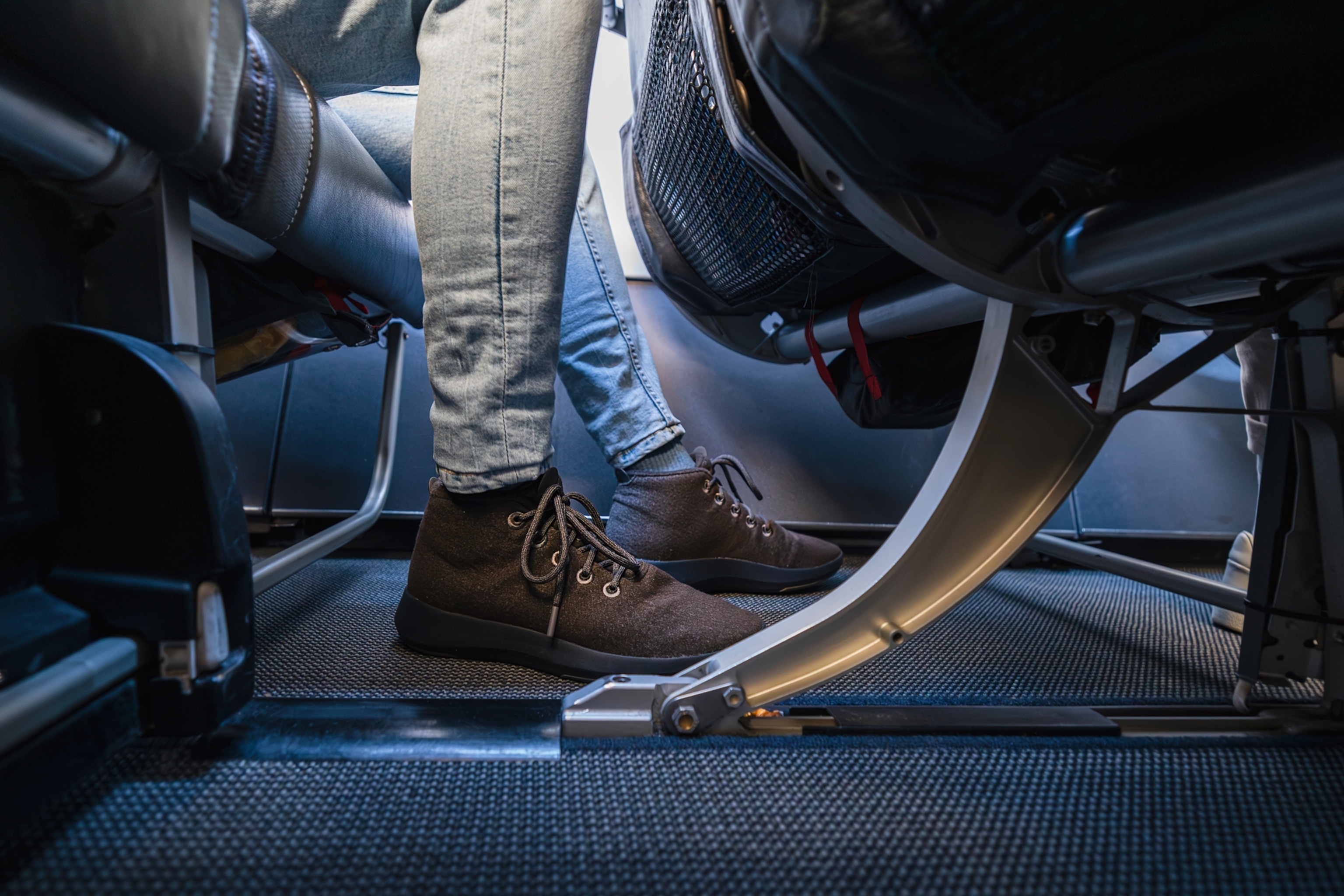 Low section of passenger seated on an airplane in economy class.