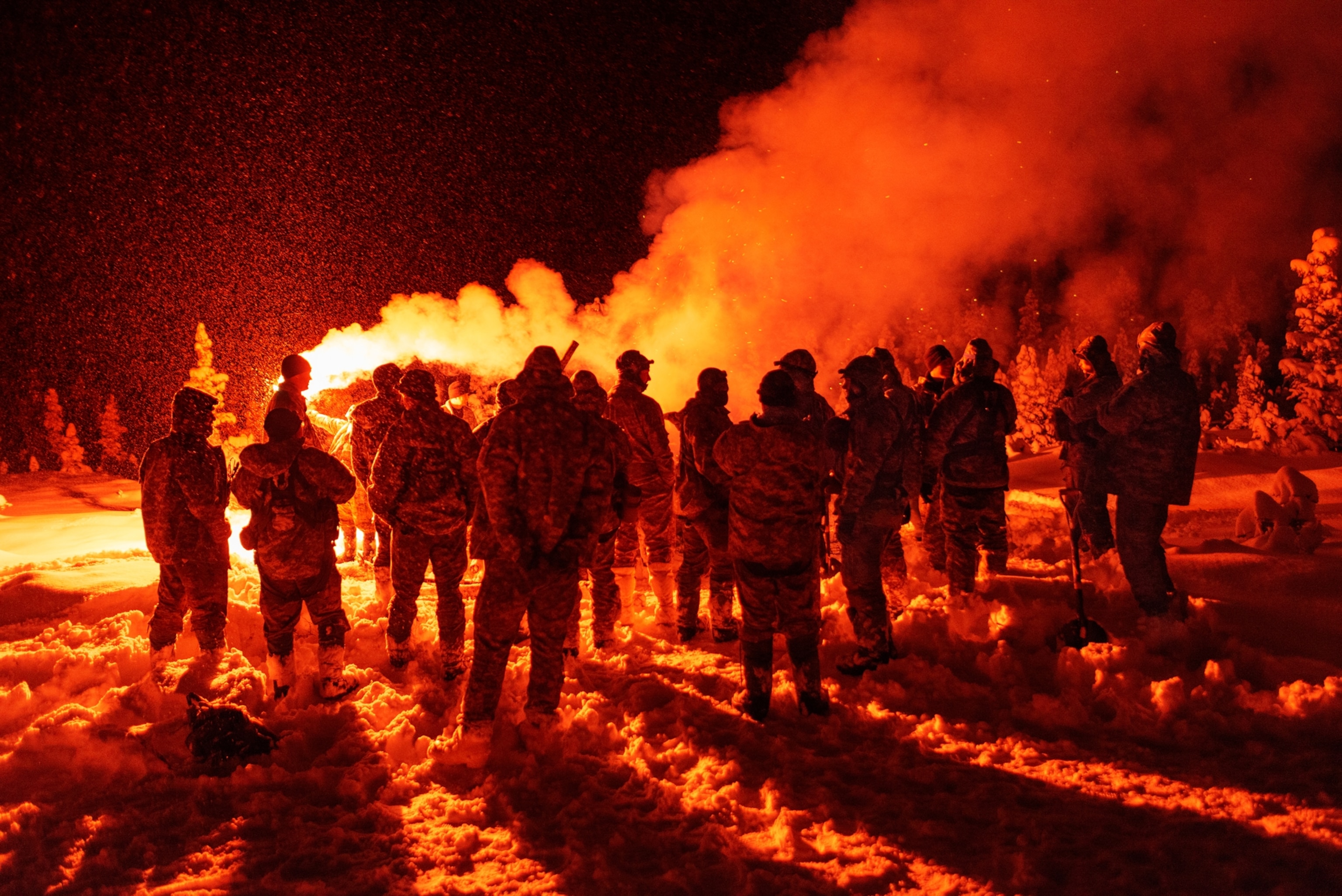 aviators watching red signal flares in darkness.