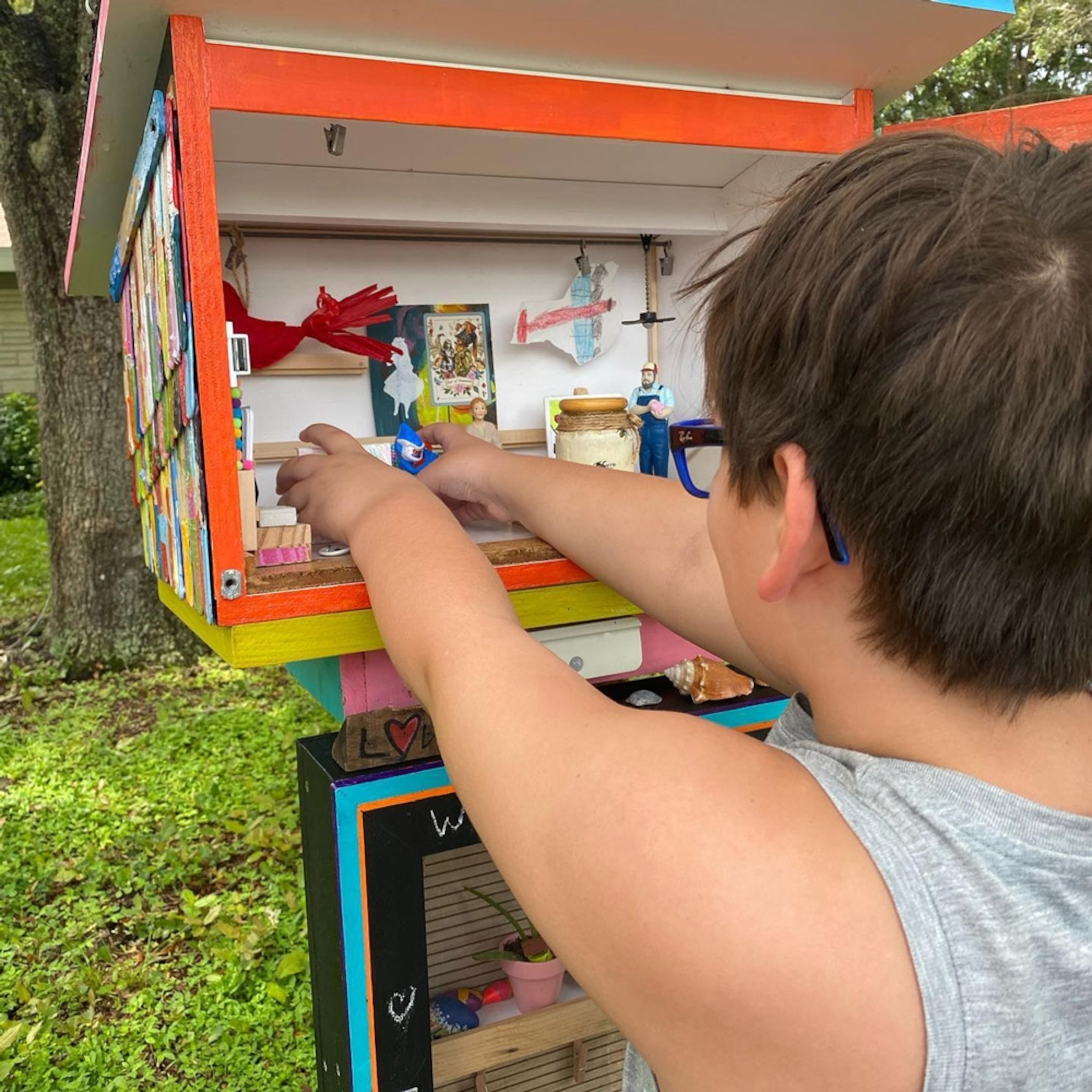 Royal Devlin placing art in a Free Little Art Gallery in Sarasota, FL. 9 years old