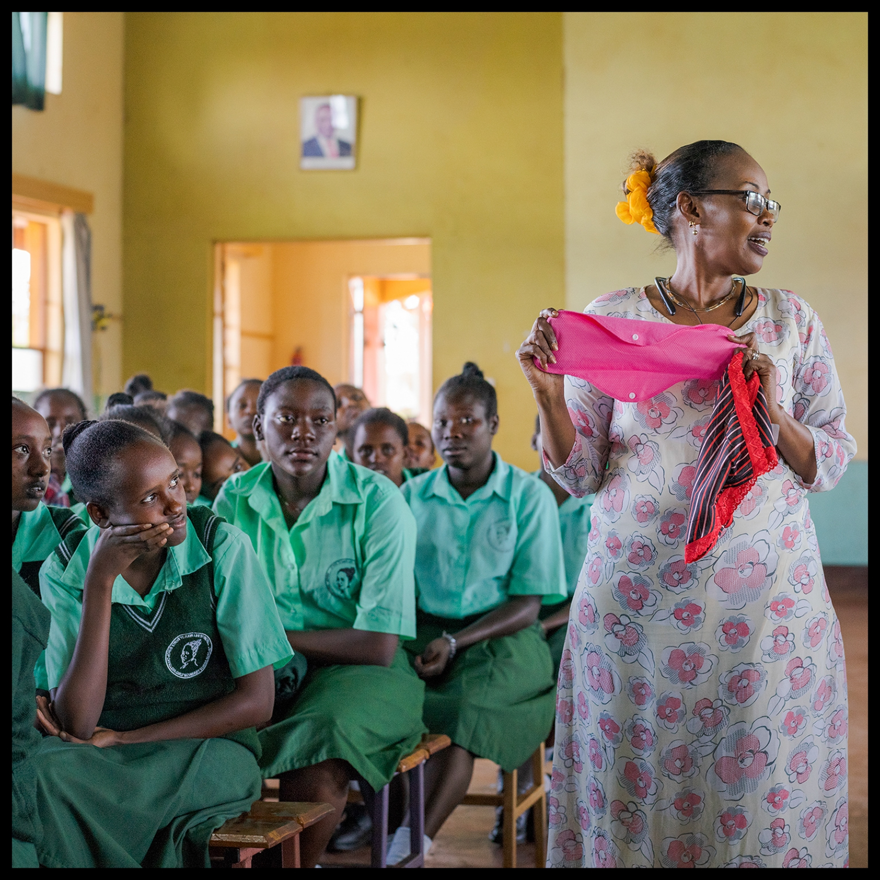 a teacher walking in between desks of a classroom filled with students