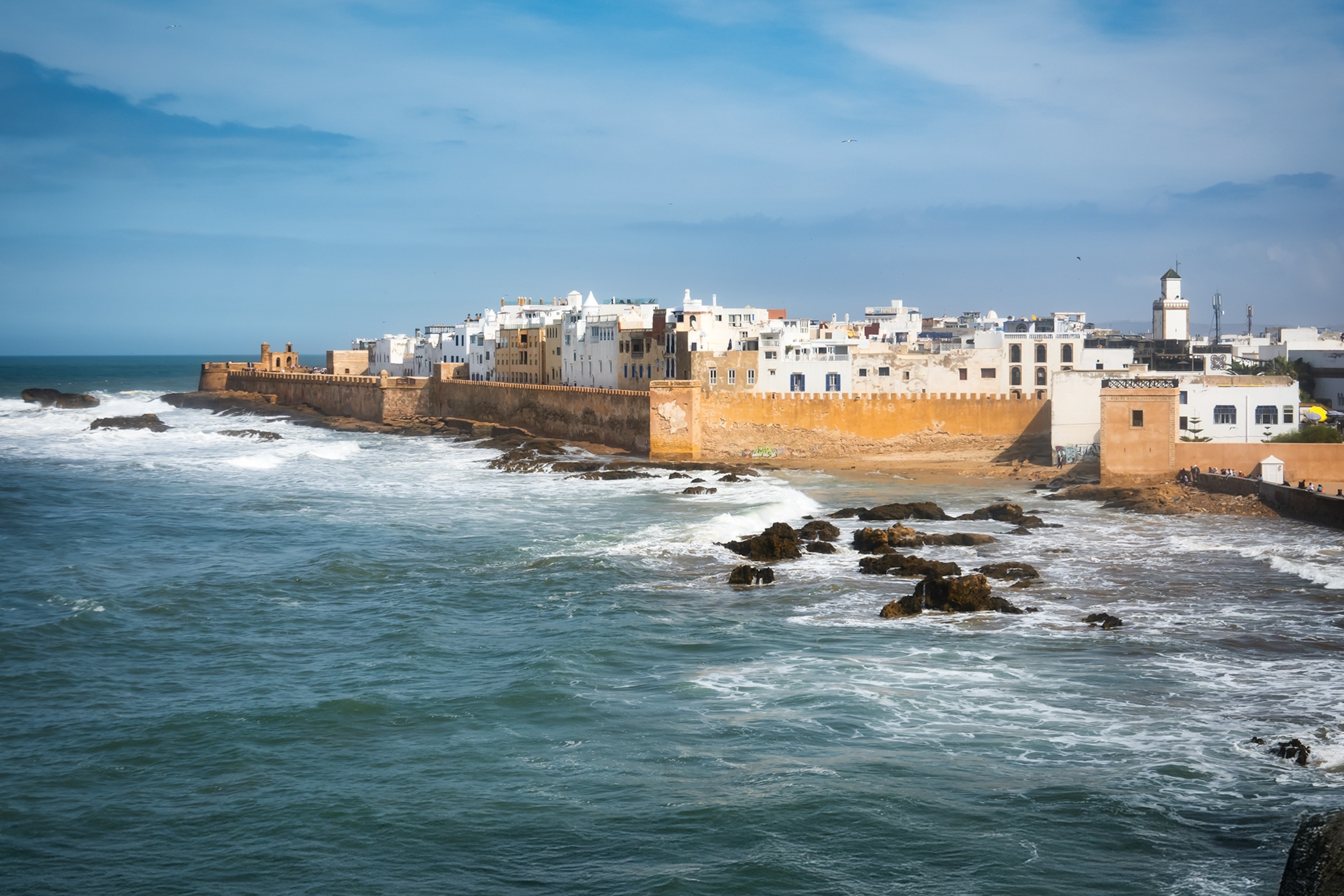 A coastal view onto a walled city built from stone