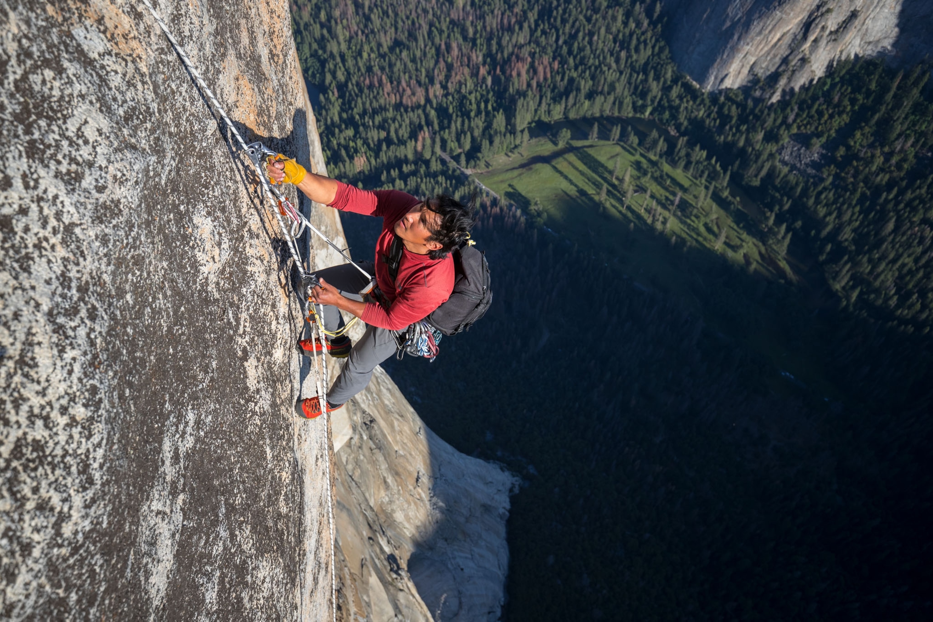 a man climbing a mountain with a rope