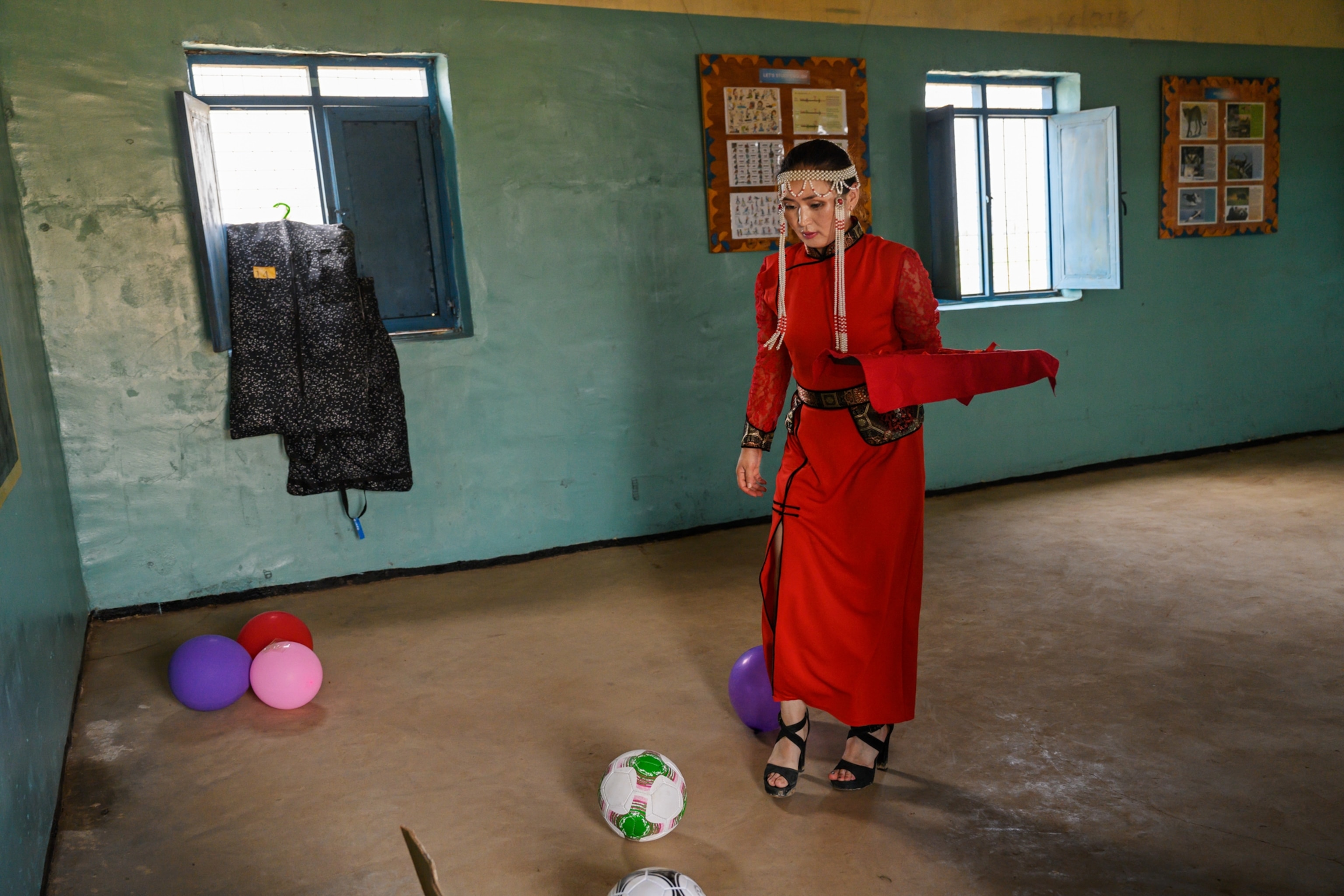 a woman in red Mongolian ceremonial clothing within a room