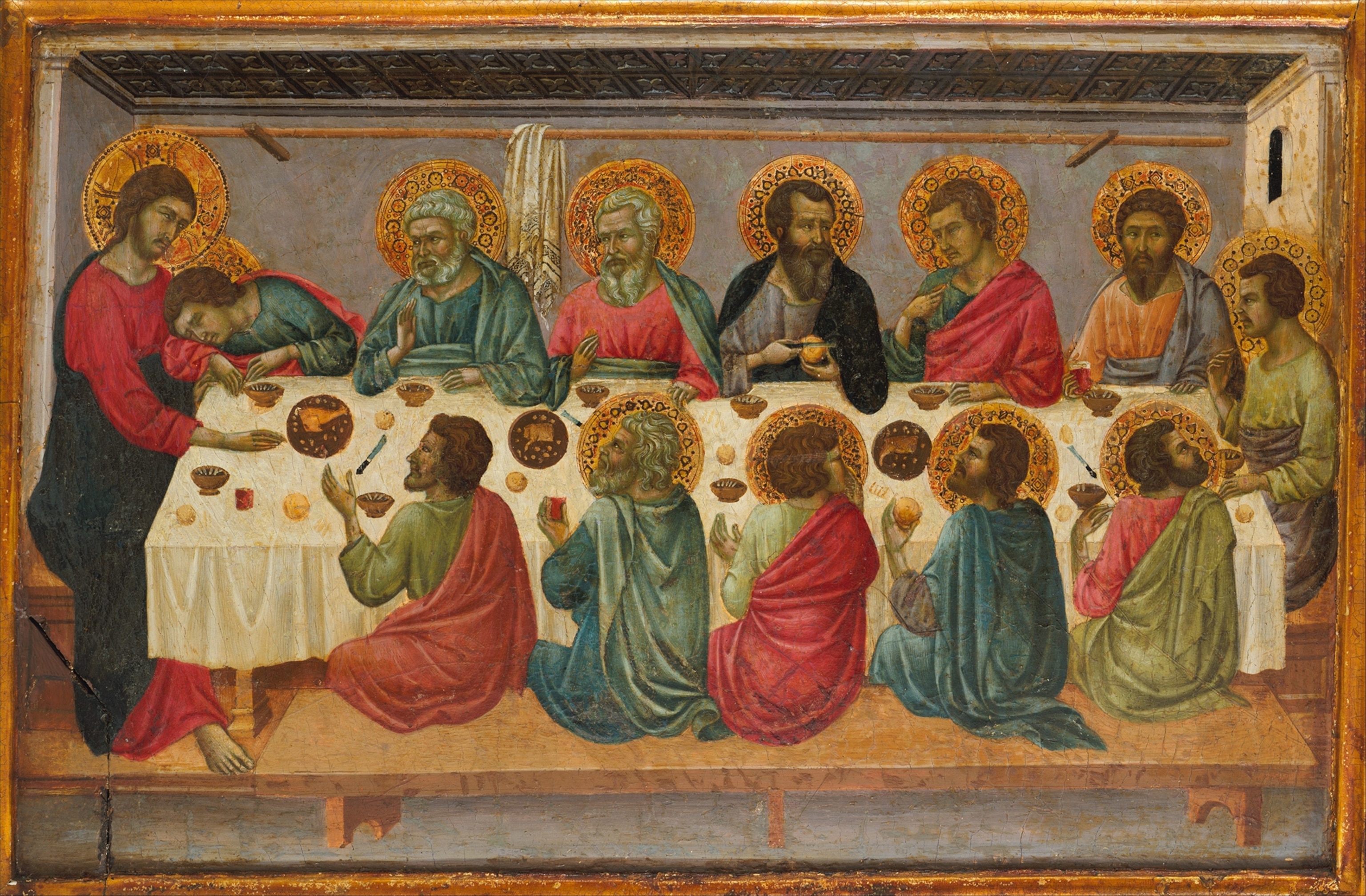 A man sits at the head of the table with others surrounding him.