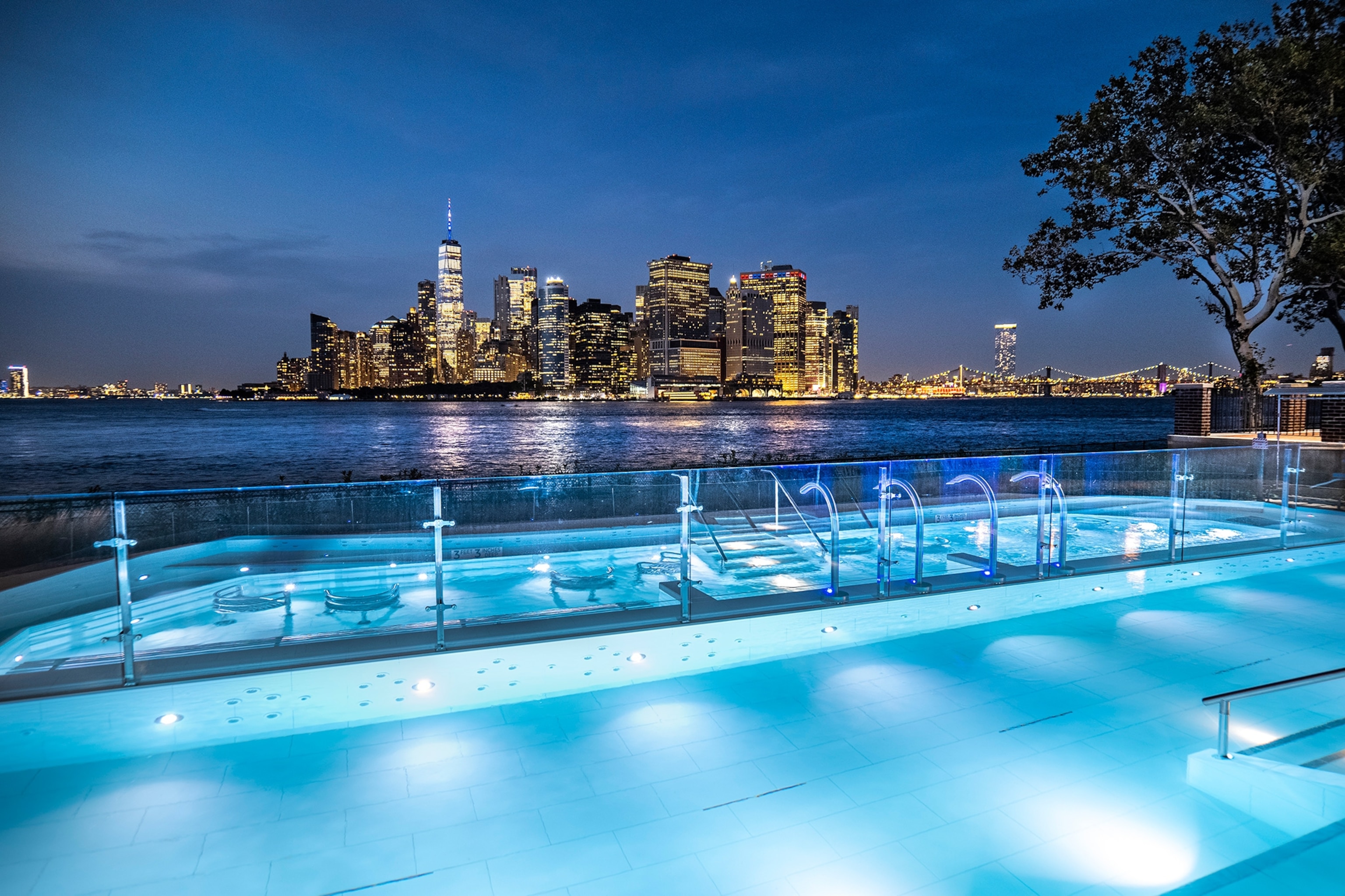 A heated panoramic pool at QC Spa NY overlooks the New York City skyline.