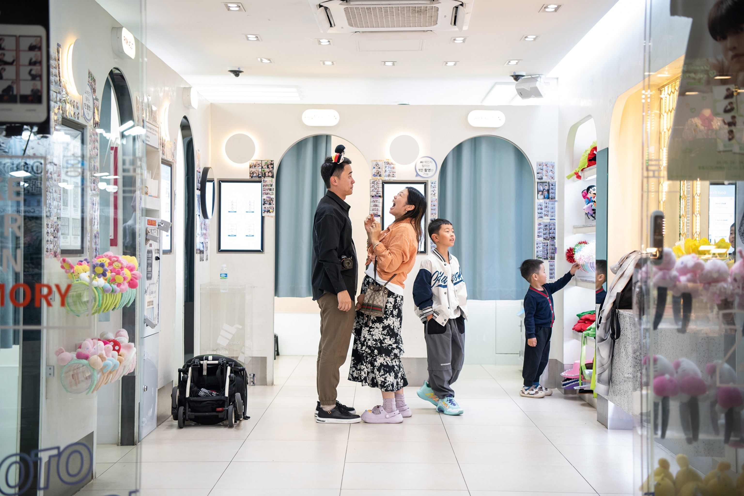 Family in a white walled shop play with costumes laughing
