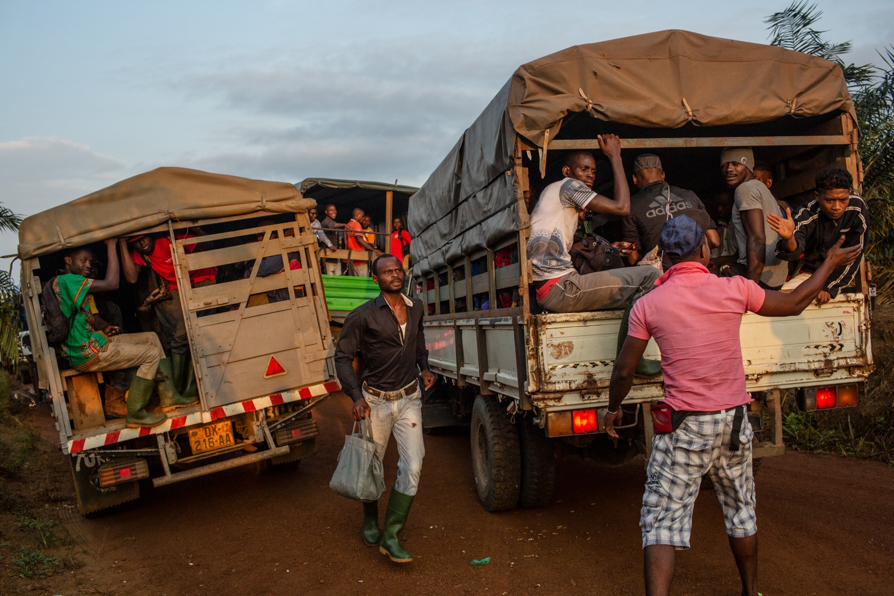 Gabonese workers gathering in the early morning to be loaded on buses