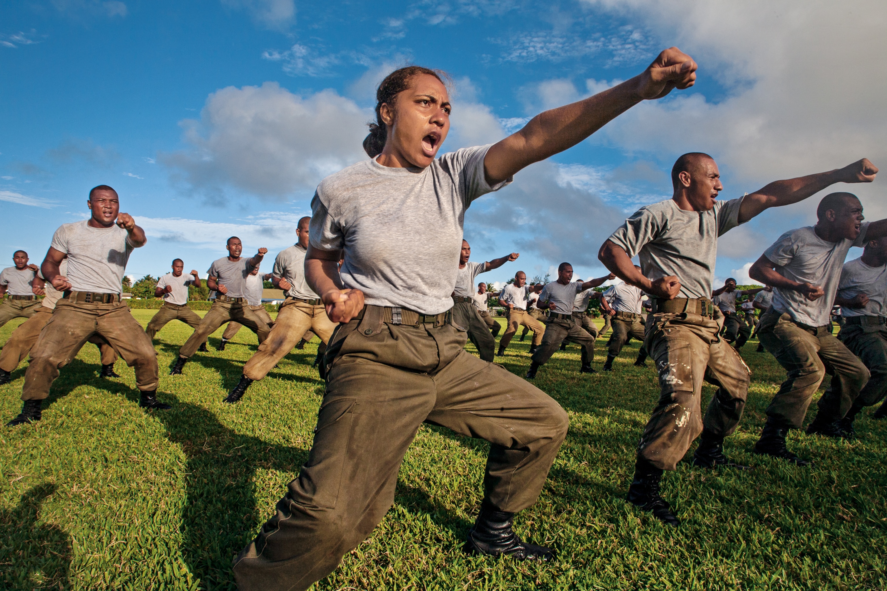a military woman practicing martial arts with men.