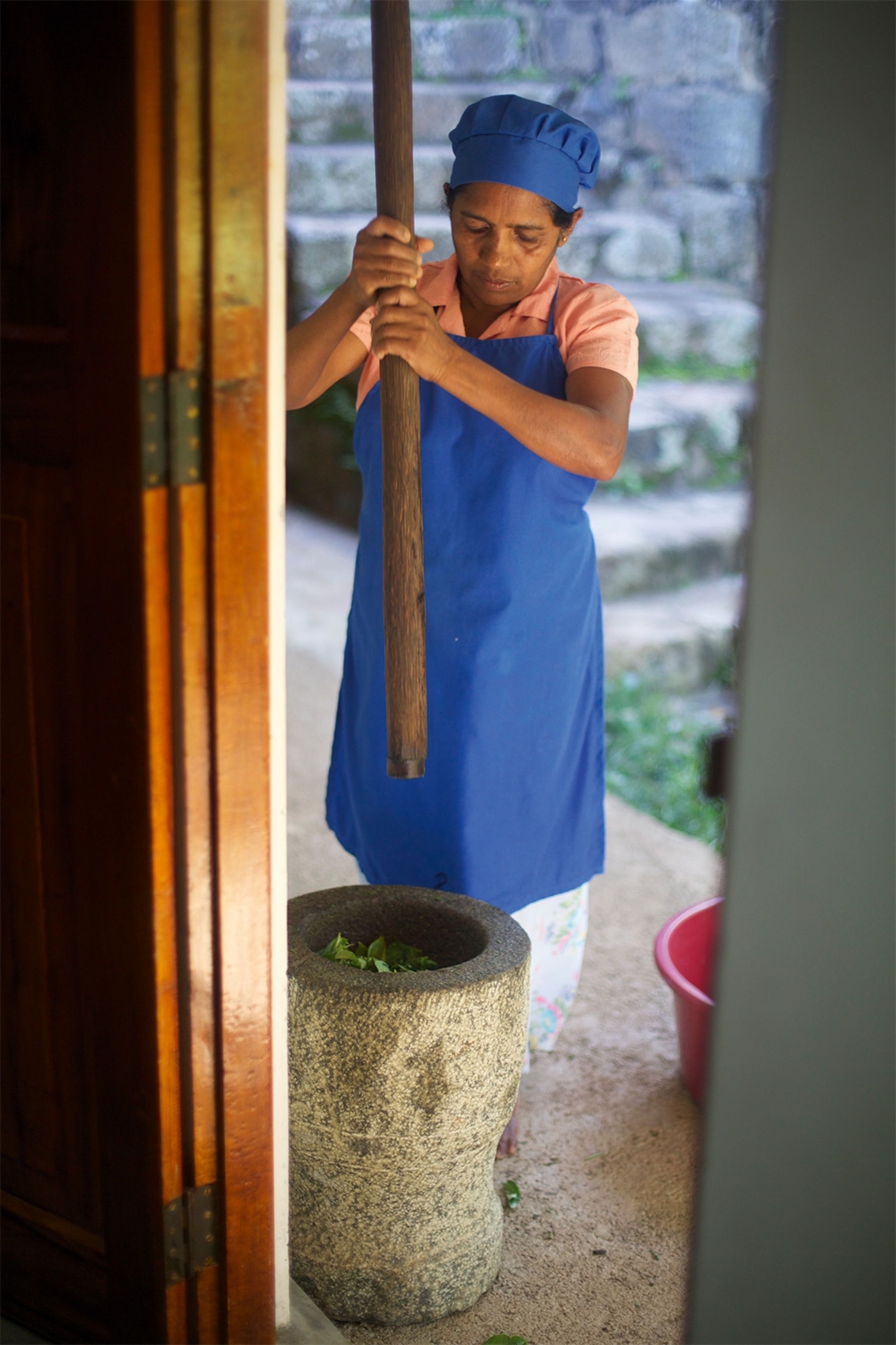 Tea leaves are pounded in a stone mortar.
