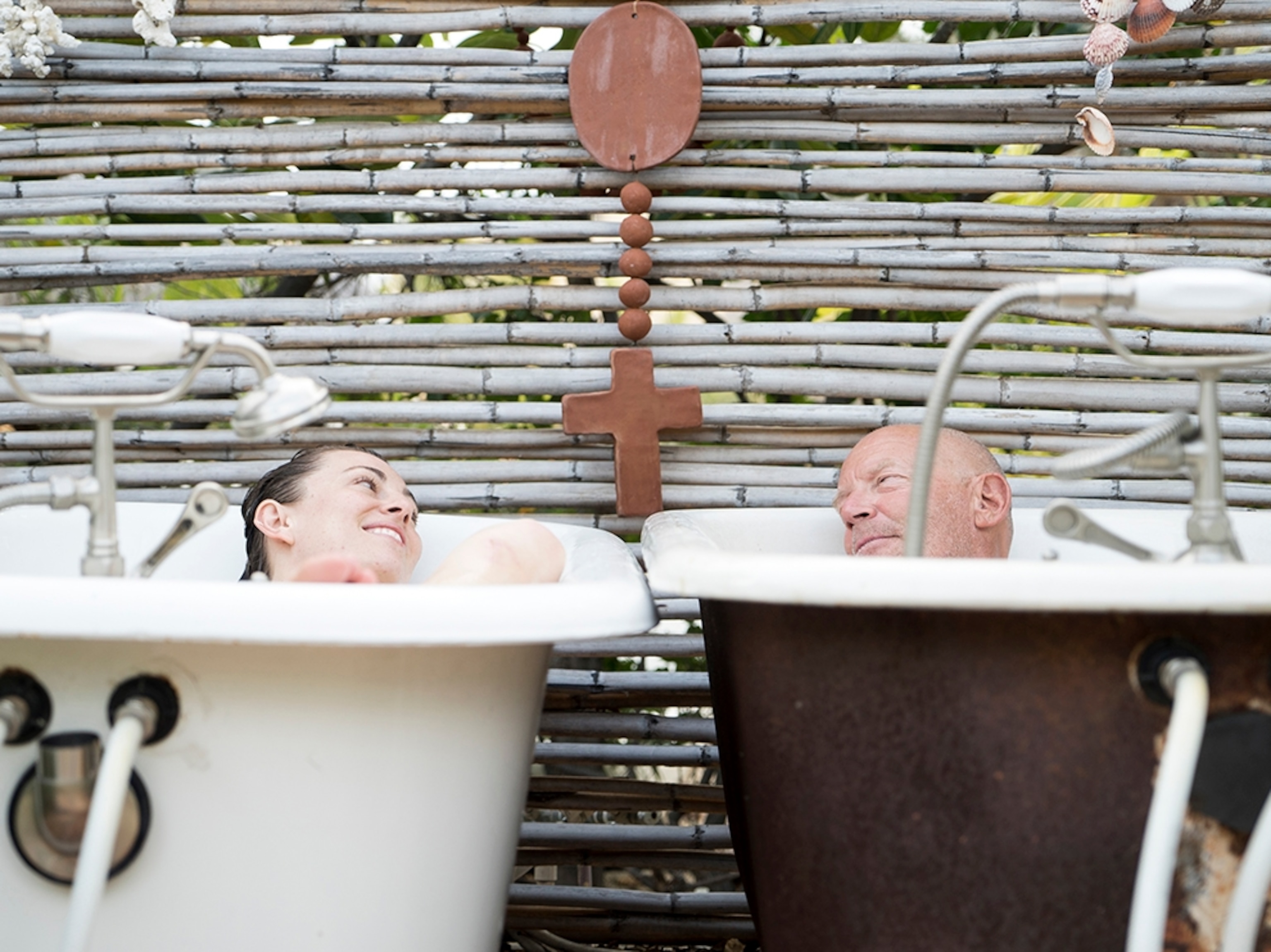 two people soaking in two outdoor bathtubs in Baja, Mexico