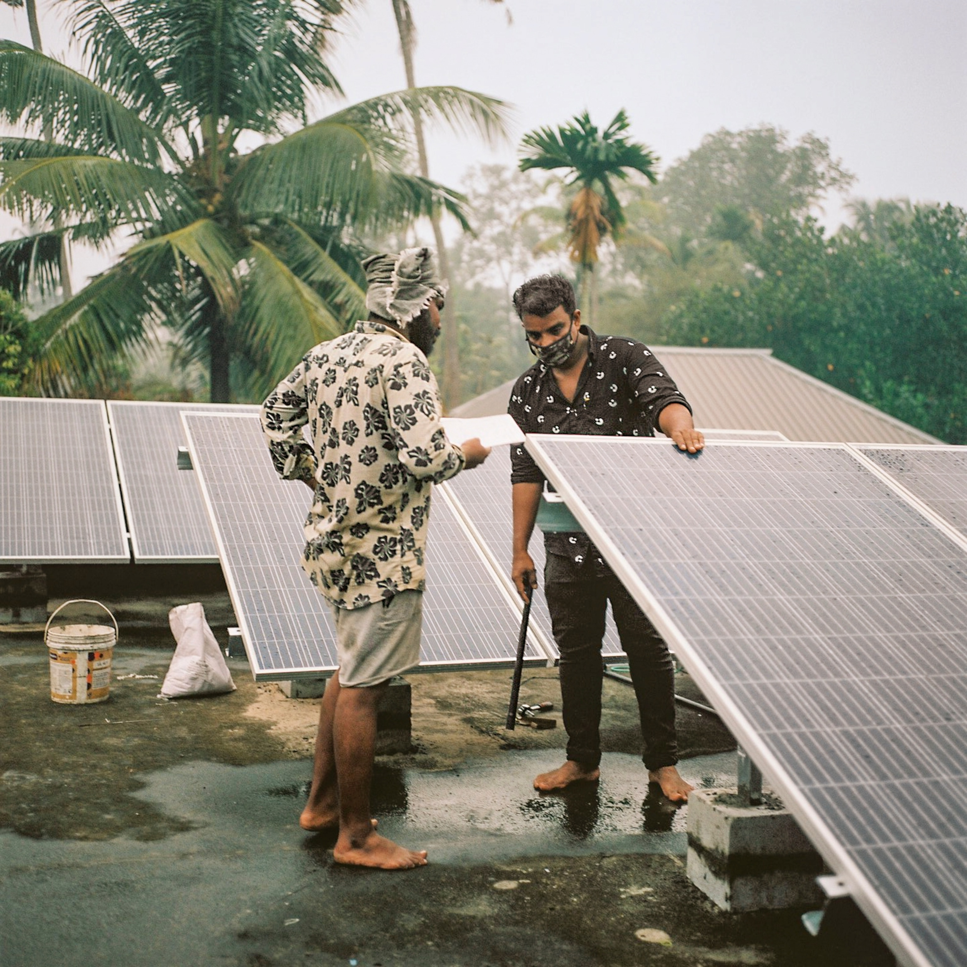 Employees of Tharayil Power, a solar energy installation company, on the roof of a house they are working on.