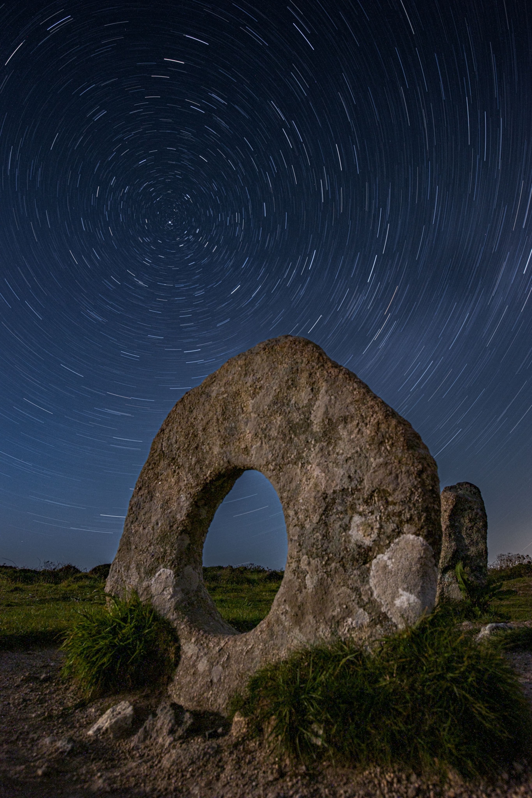 stars above a stone with a hole in the center of it known as Mên-an-Tol