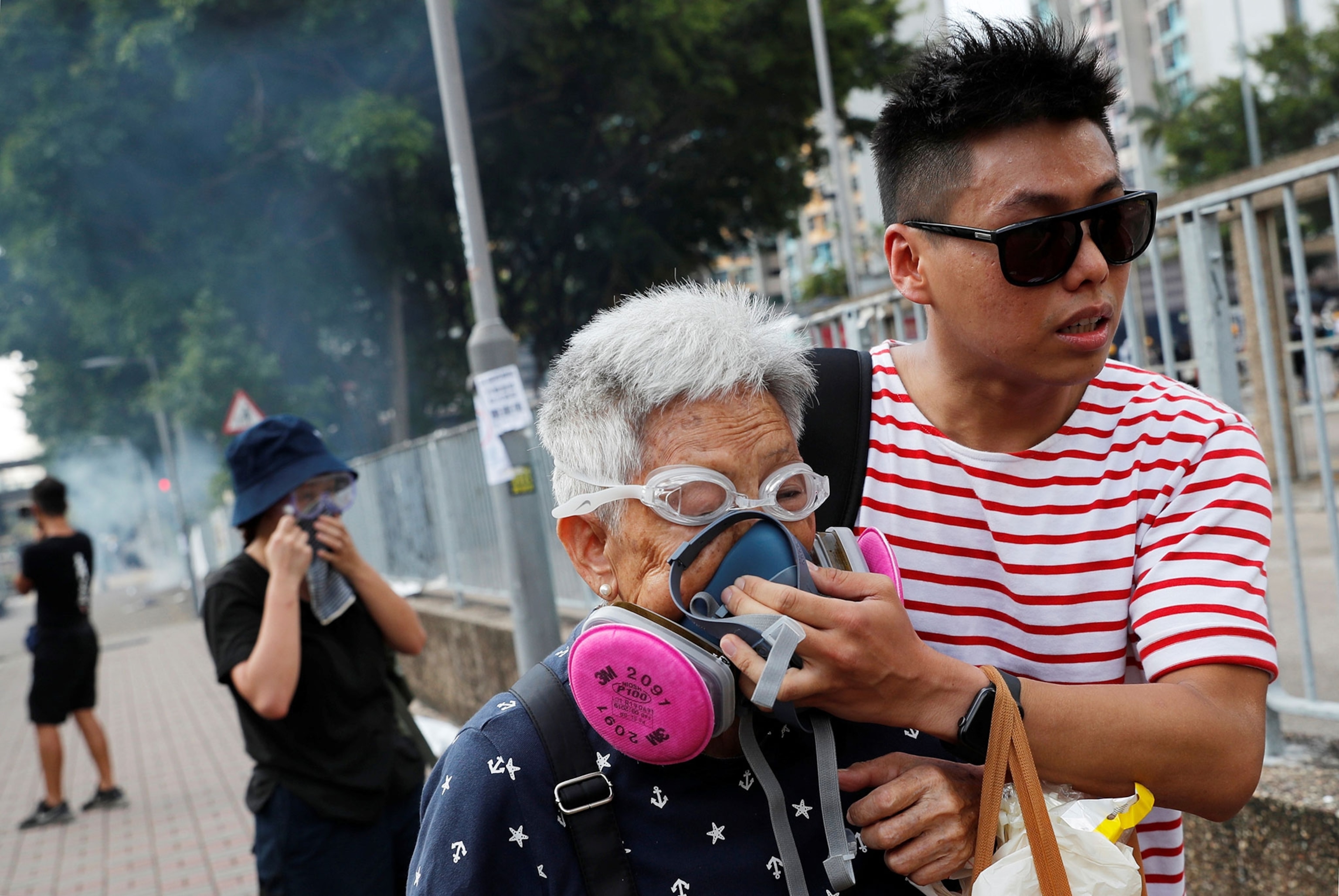 a man helping an elderly woman during a protest in Hong Kong